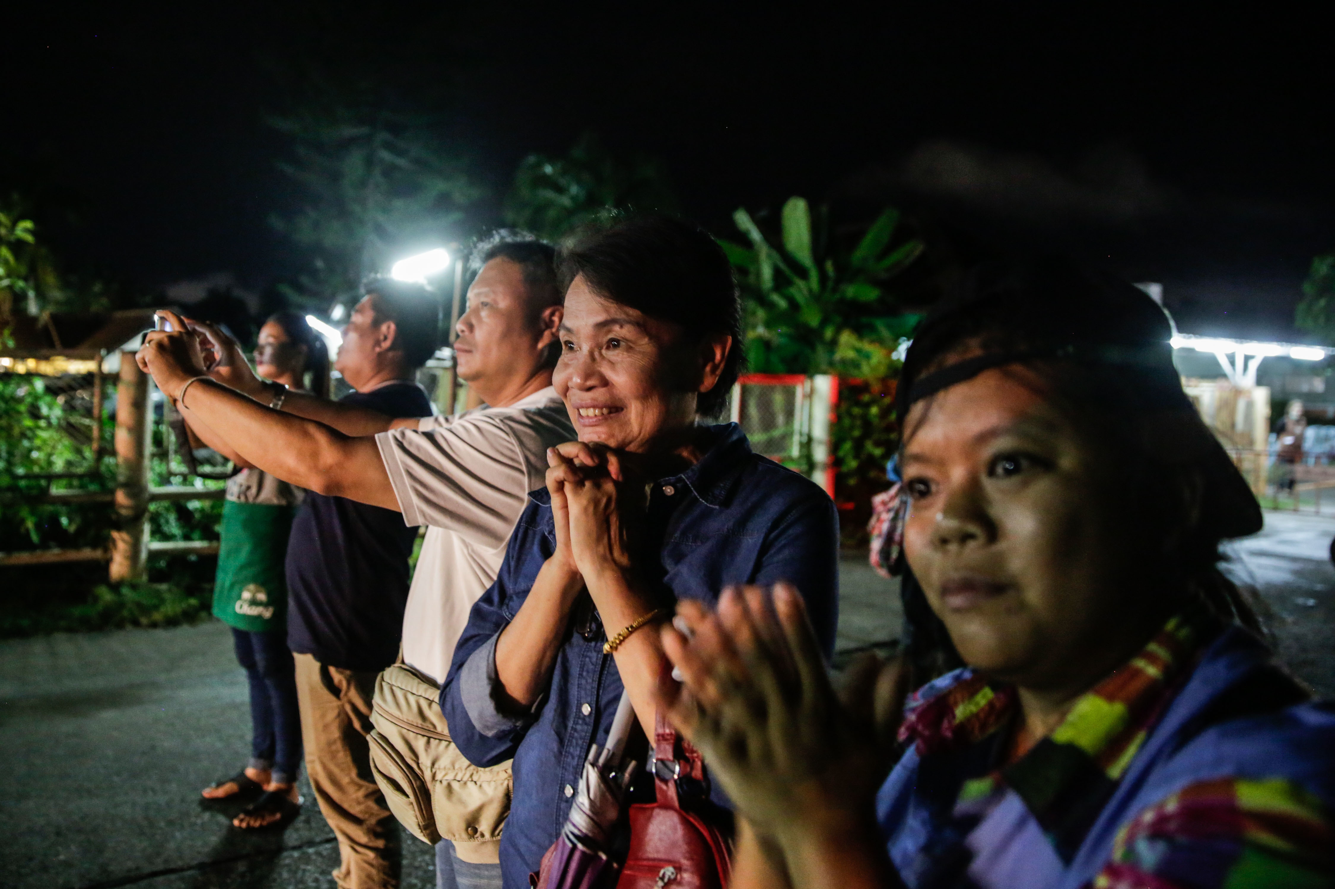 Onlookers watch and cheer as ambulances deliver boys rescued from a cave in northern Thailand to a hospital in Chiang Rai on Sunday. (Getty Images)