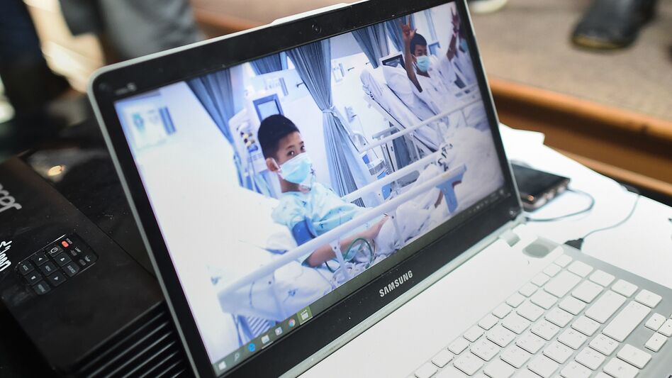 Local government workers on Wednesday display the newly released video footage of the rescued soccer players, who are currently recuperating in hospital beds.