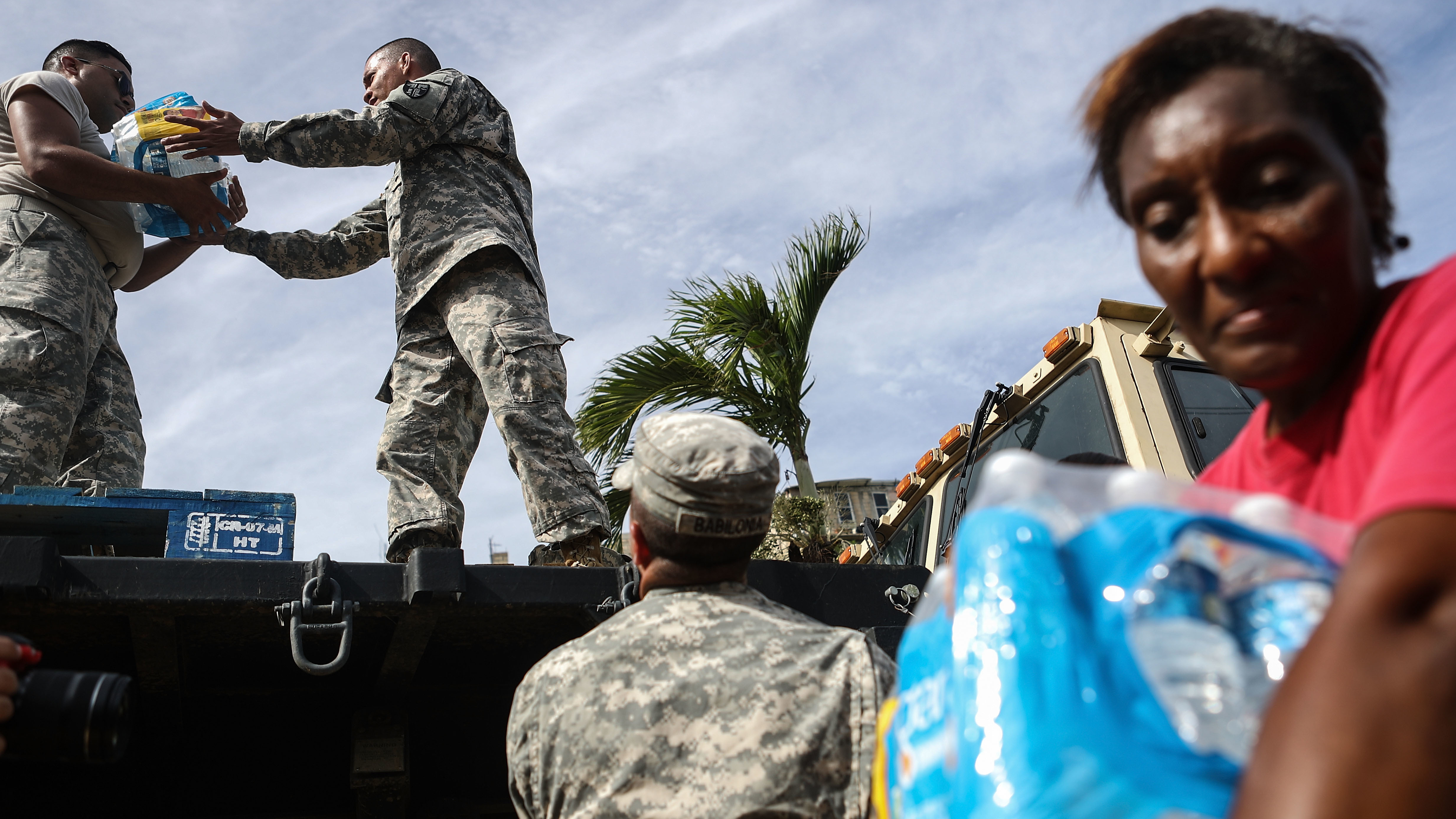 U.S. Army soldiers pass out water, provided by FEMA, to residents in a neighborhood without grid electricity or running water in San Isidro, Puerto Rico, on Oct. 17, 2017. (Getty Images)
