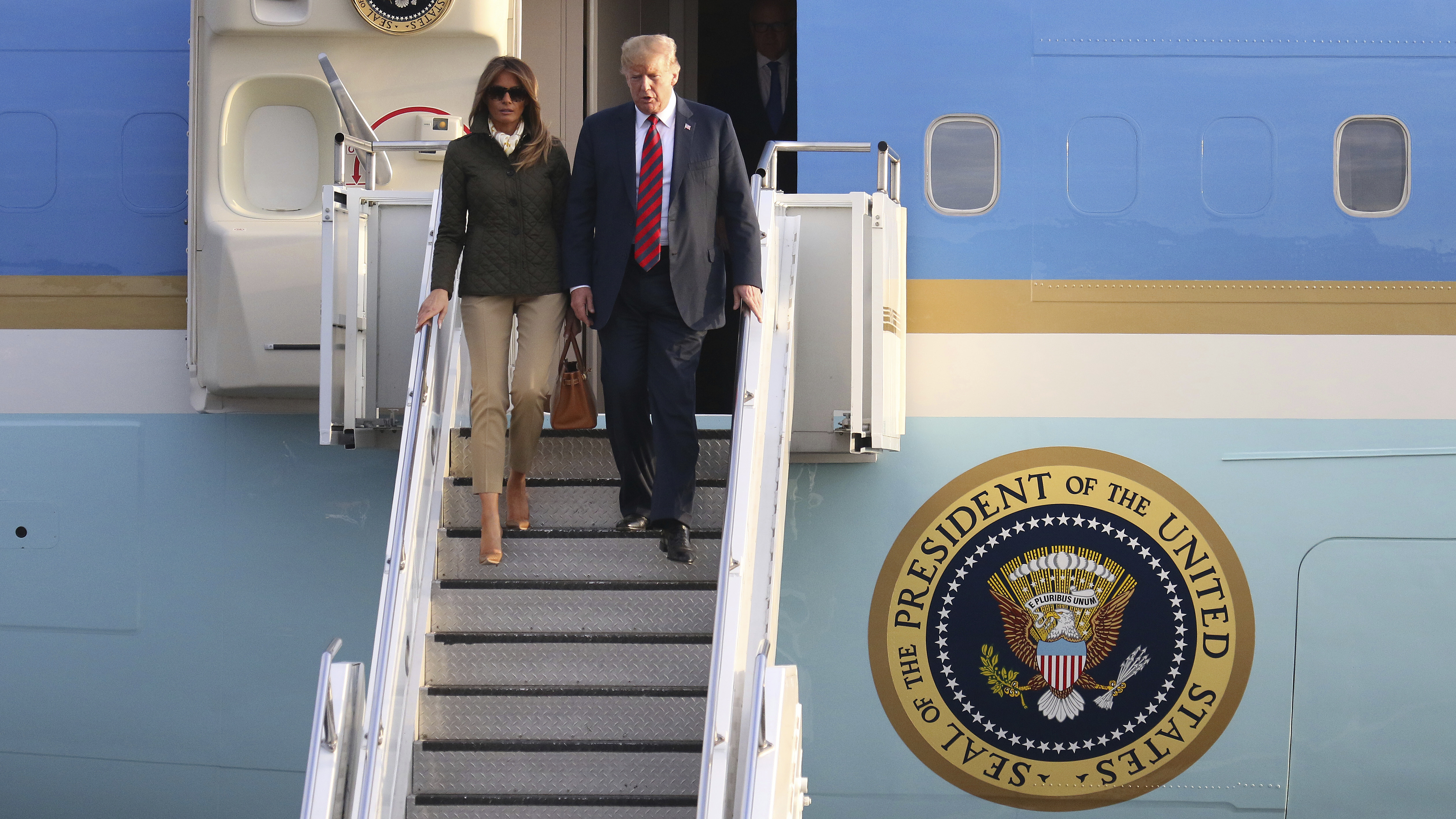 U.S. President Donald Trump and first lady Melania Trump disembark from Air Force One as they arrived in  Scotland on Friday.