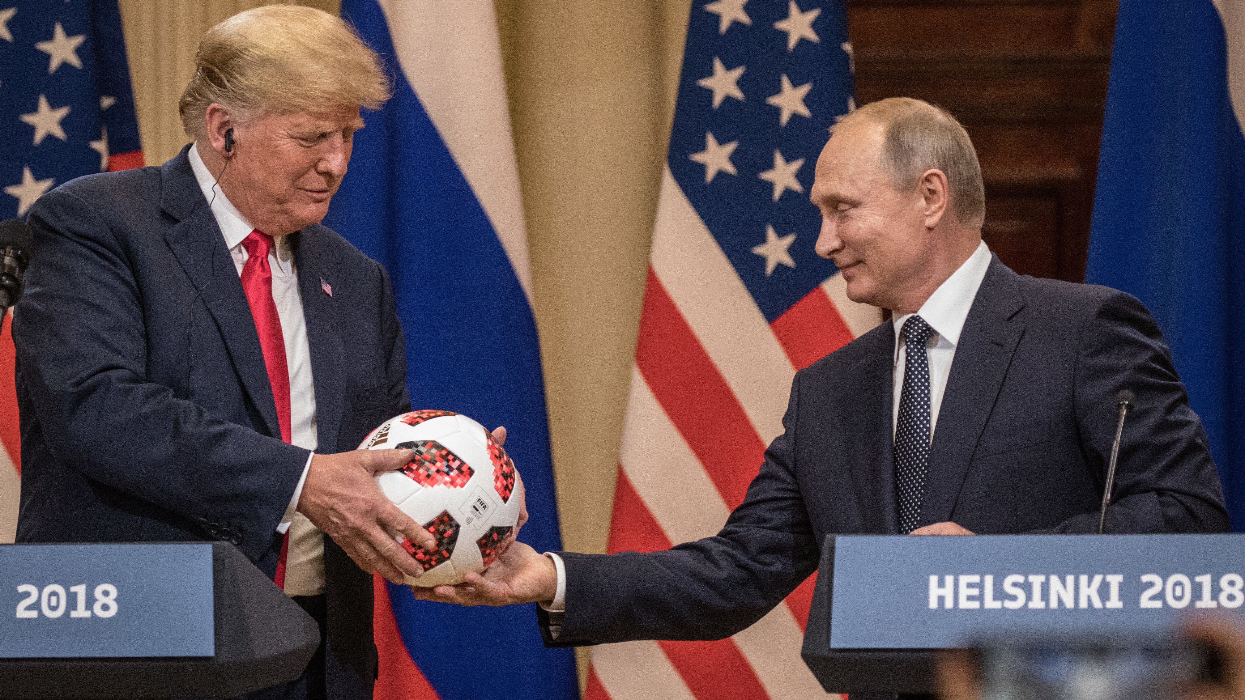 Russian President Vladimir Putin hands President Trump a World Cup soccer ball during a joint news conference after their summit on Monday in Helsinki.