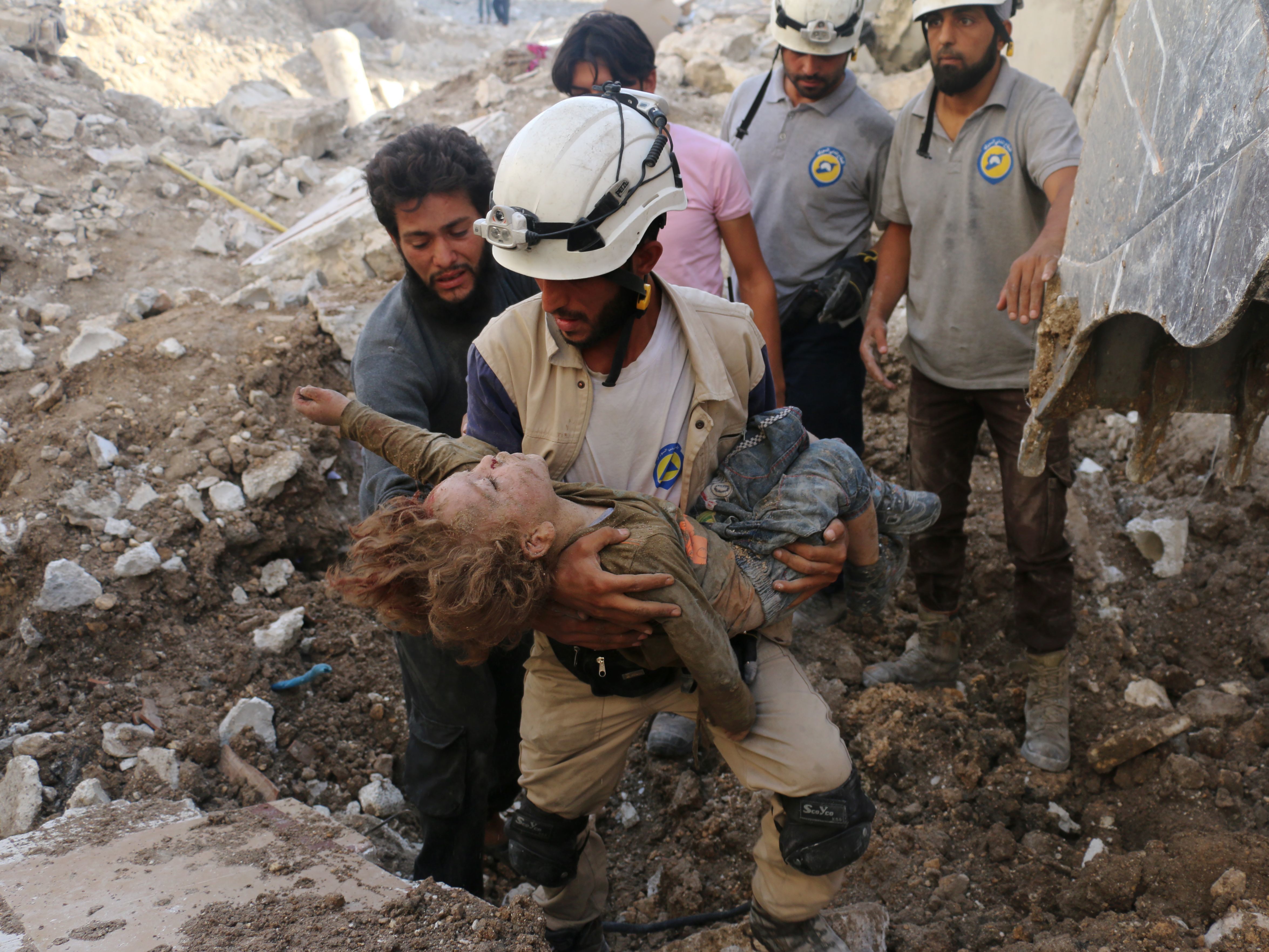 A Syrian Civil Defense volunteer, known as the White Helmets, holds the body of a child after he was pulled from the rubble following a government forces airstrike on the rebel-held neighborhood of Karm Homad in the northern city of Aleppo on Oct. 4, 2016. (AFP/Getty Images)