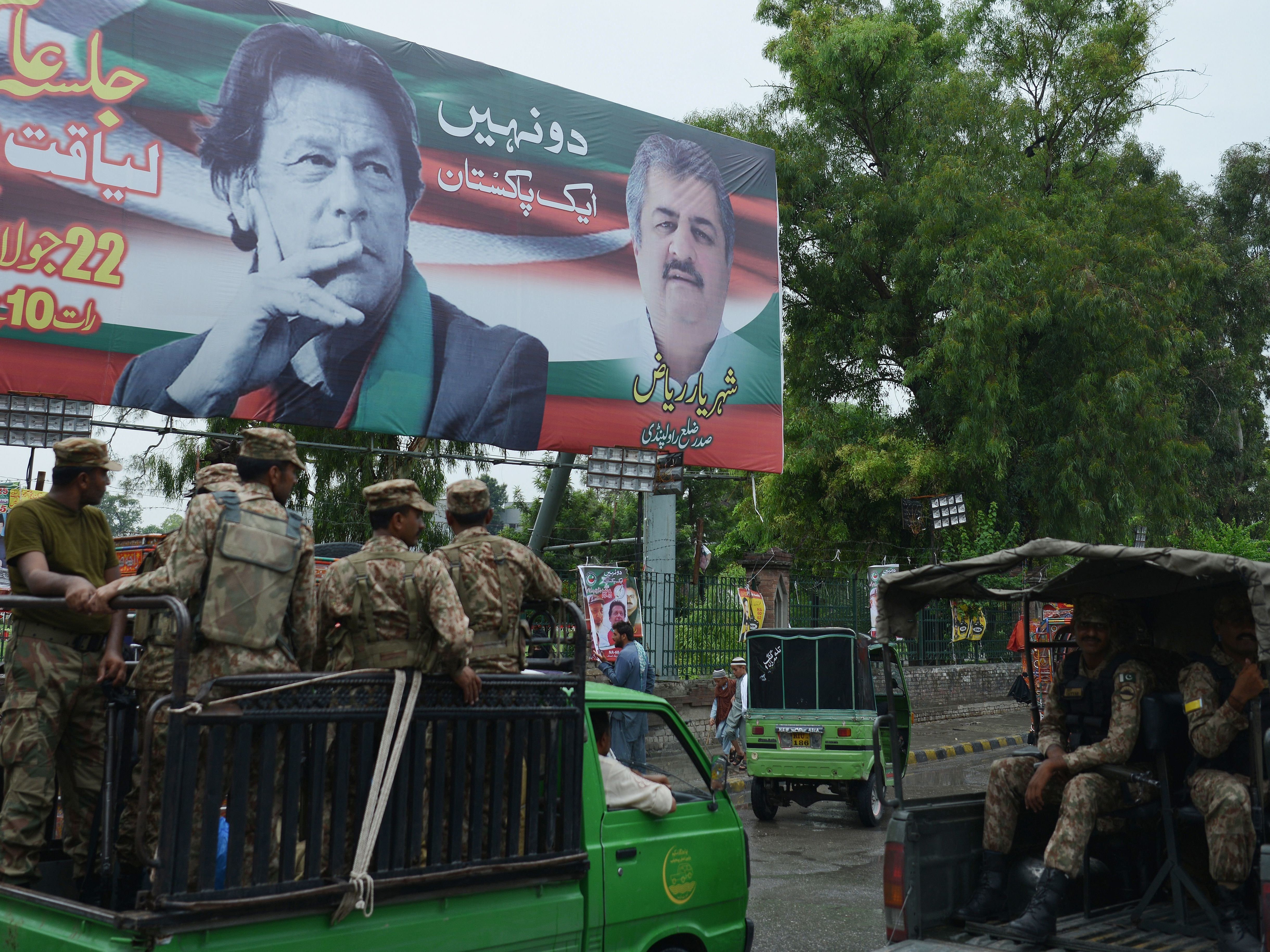 Pakistani soldiers patrol on a street beside a billboard featuring an image of Imran Khan of the Pakistan Tehreek-e-Insaf (Movement for Justice), in Rawalpindi. (AFP/Getty Images)