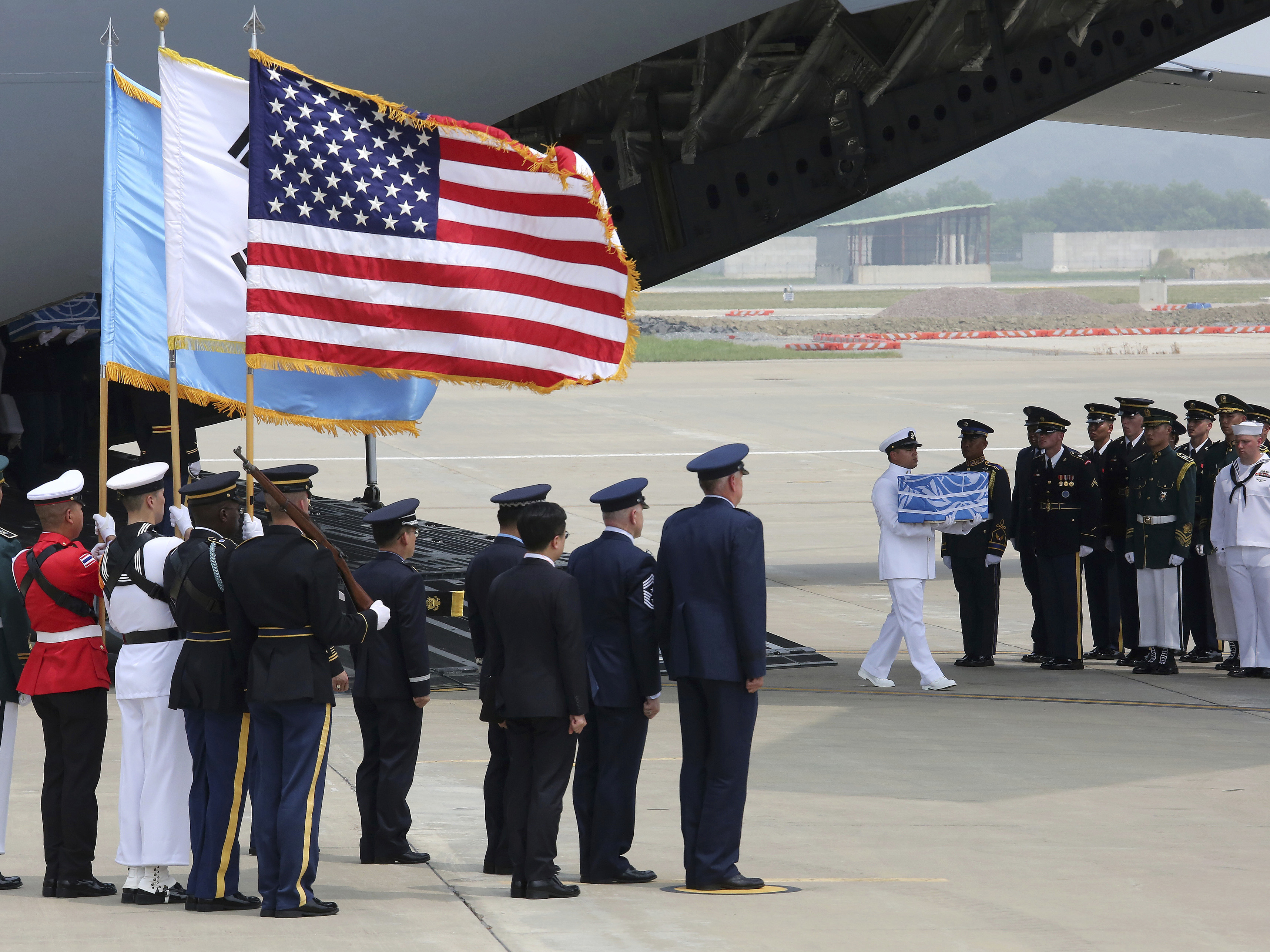 A U.N. honor guard at Osan Air Base in Pyeongtaek, South Korea, carries a box containing remains believed to be from American servicemen killed during the Korean War after they arrived from North Korea on Friday.
