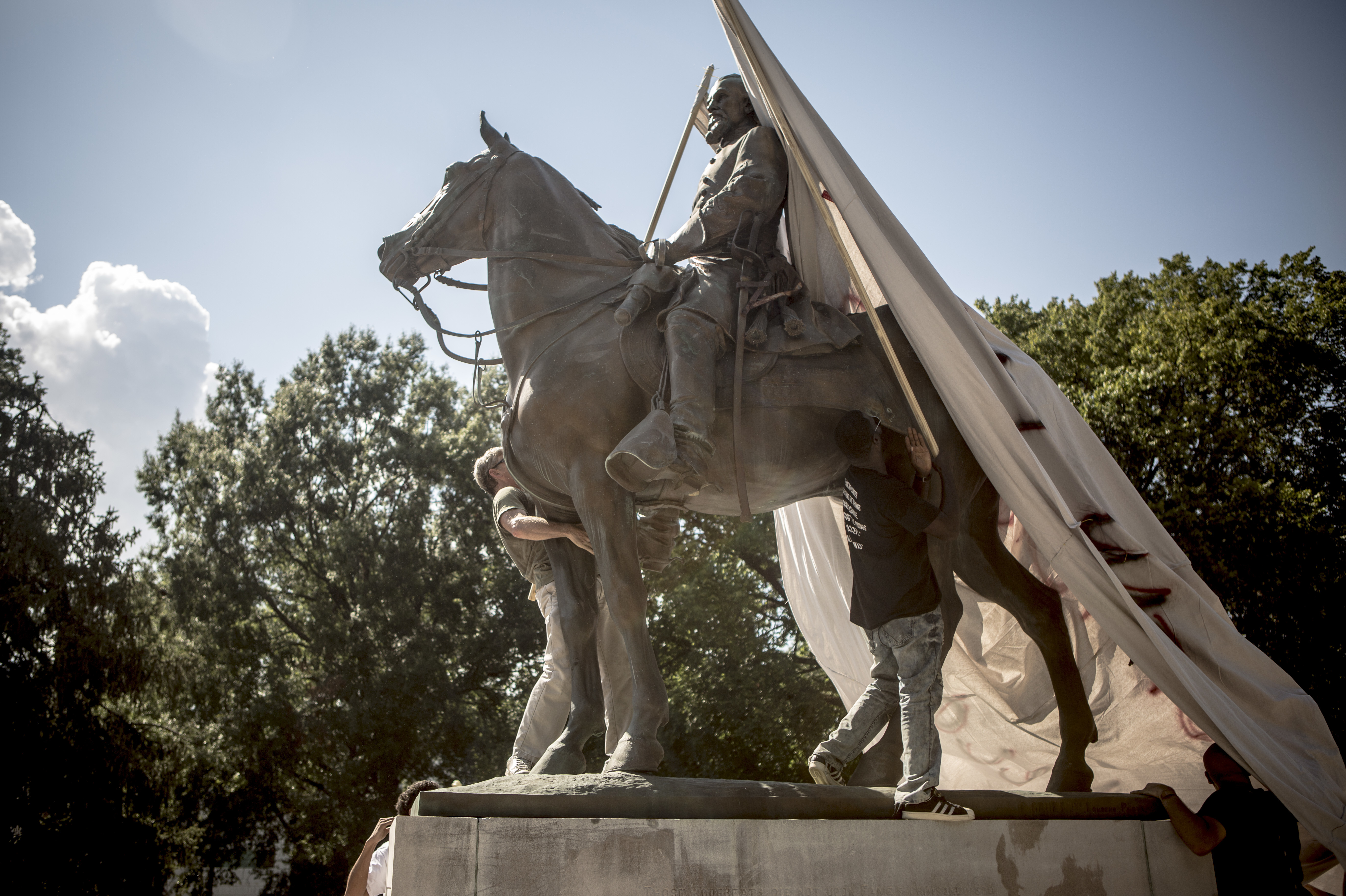 Protesters attempt to cover a statue of Ku Klux Klan leader Nathan Bedford Forrest at Health Sciences Park in Memphis, Tenn., in August 2017. The statue was removed in December. (Andrea Morales)