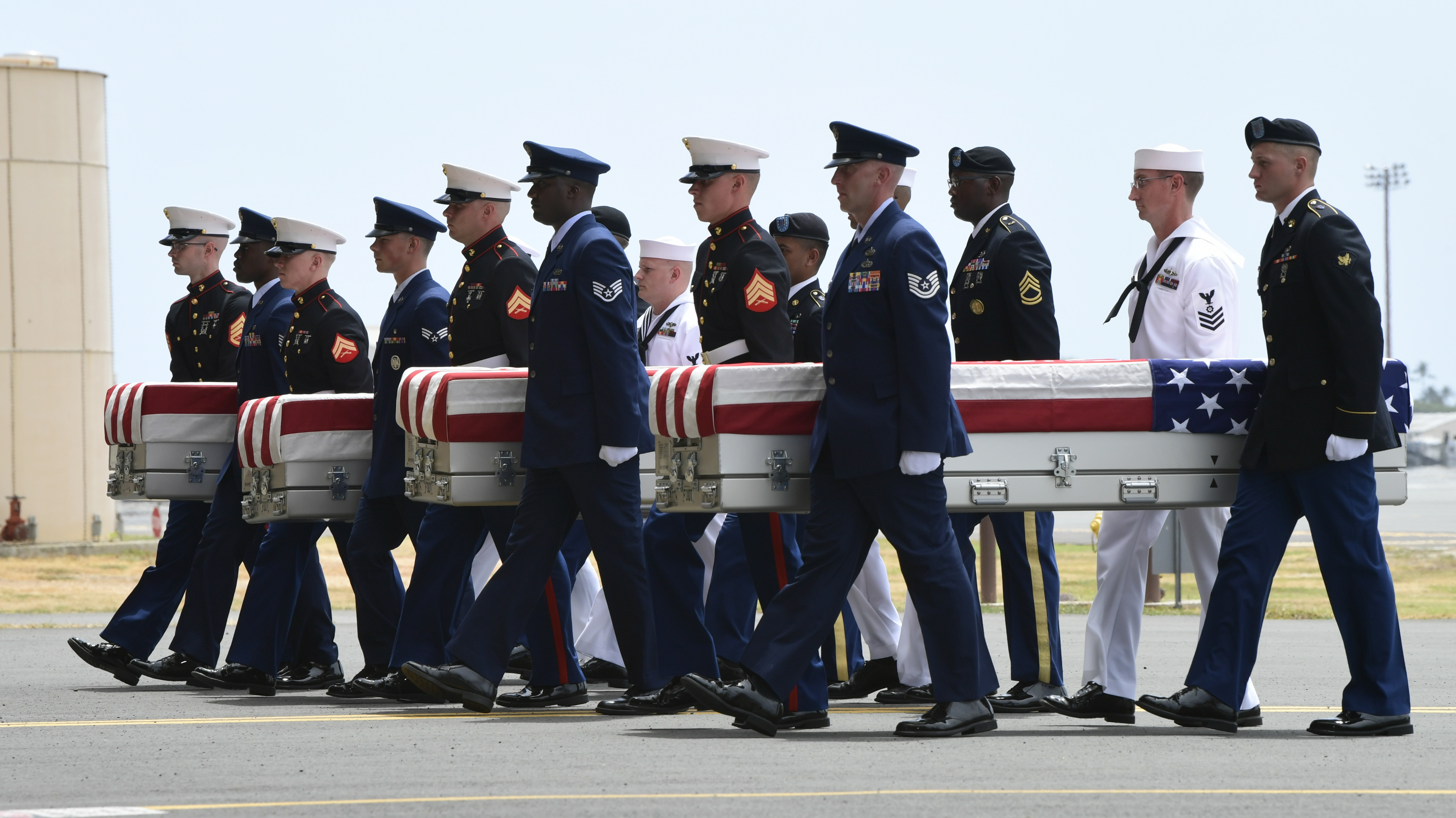 Military members carry transfer cases from a C-17 at a ceremony marking the arrival of the remains believed to be of American service members who fell in the Korean War at Joint Base Pearl Harbor-Hickam in Hawaii, on Wednesday.
