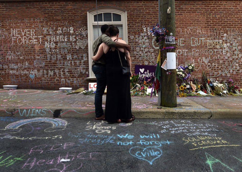 Lindsey Reisser, 25, and her fiance Carl Thomas, 25, bring flowers to the site her friend Heather Heyer died last year at the Unite the Right rally. "Heather was a very close friend of mine," she said weeping. "I asked her not to go. It didn't feel right, there was tension in Charlottesville." (Carol Guzy for NPR)