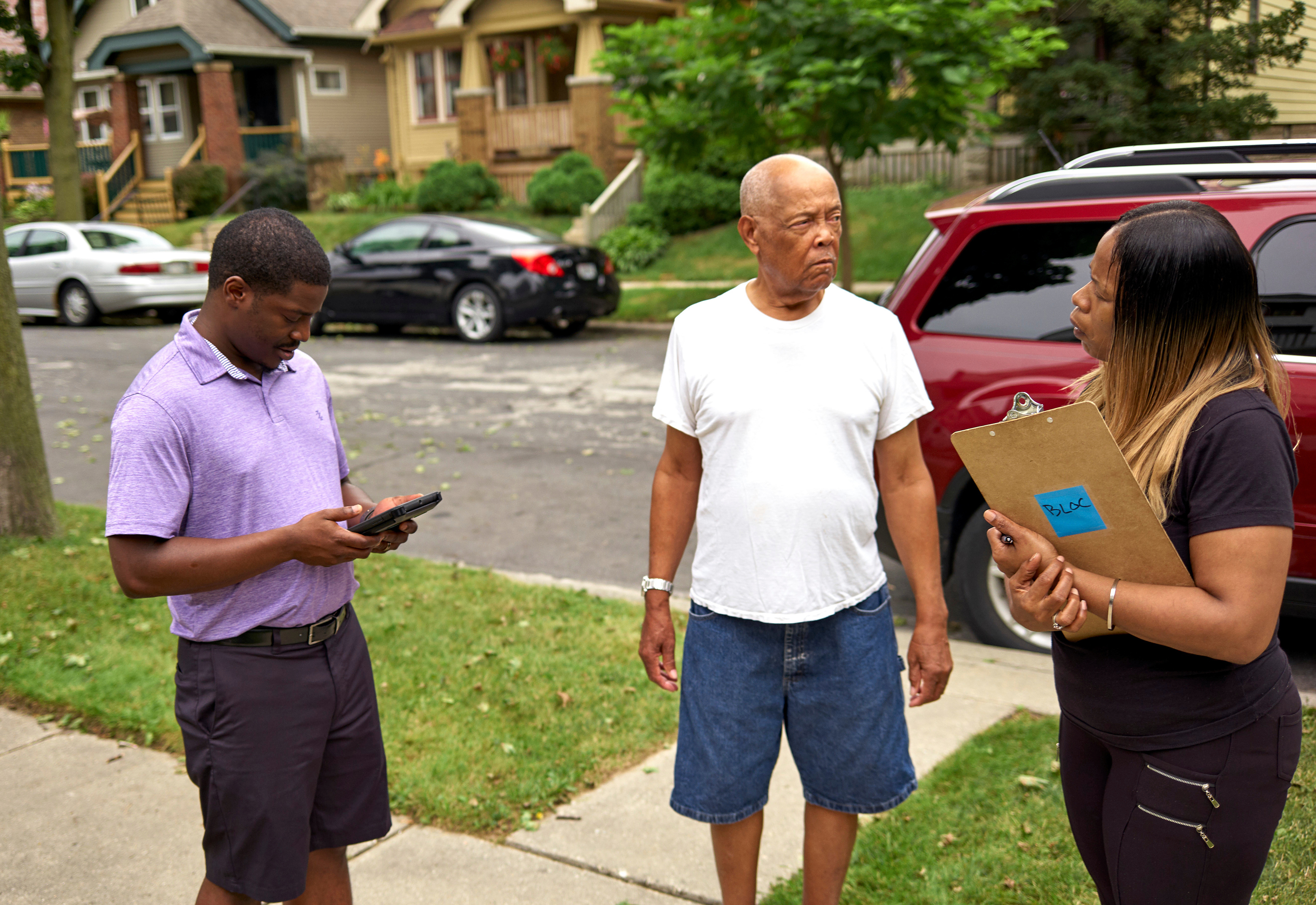 Wisconsin State Rep. David Crowley, left, works with Keisha Robinson, right, of BLOC, Black Leaders Organizing for Communities as he takes part in a silent canvass where Mr. Crowley is only allowed to listen to community members like George McBeth, center, Aug. 8, 2018 Milwaukee.