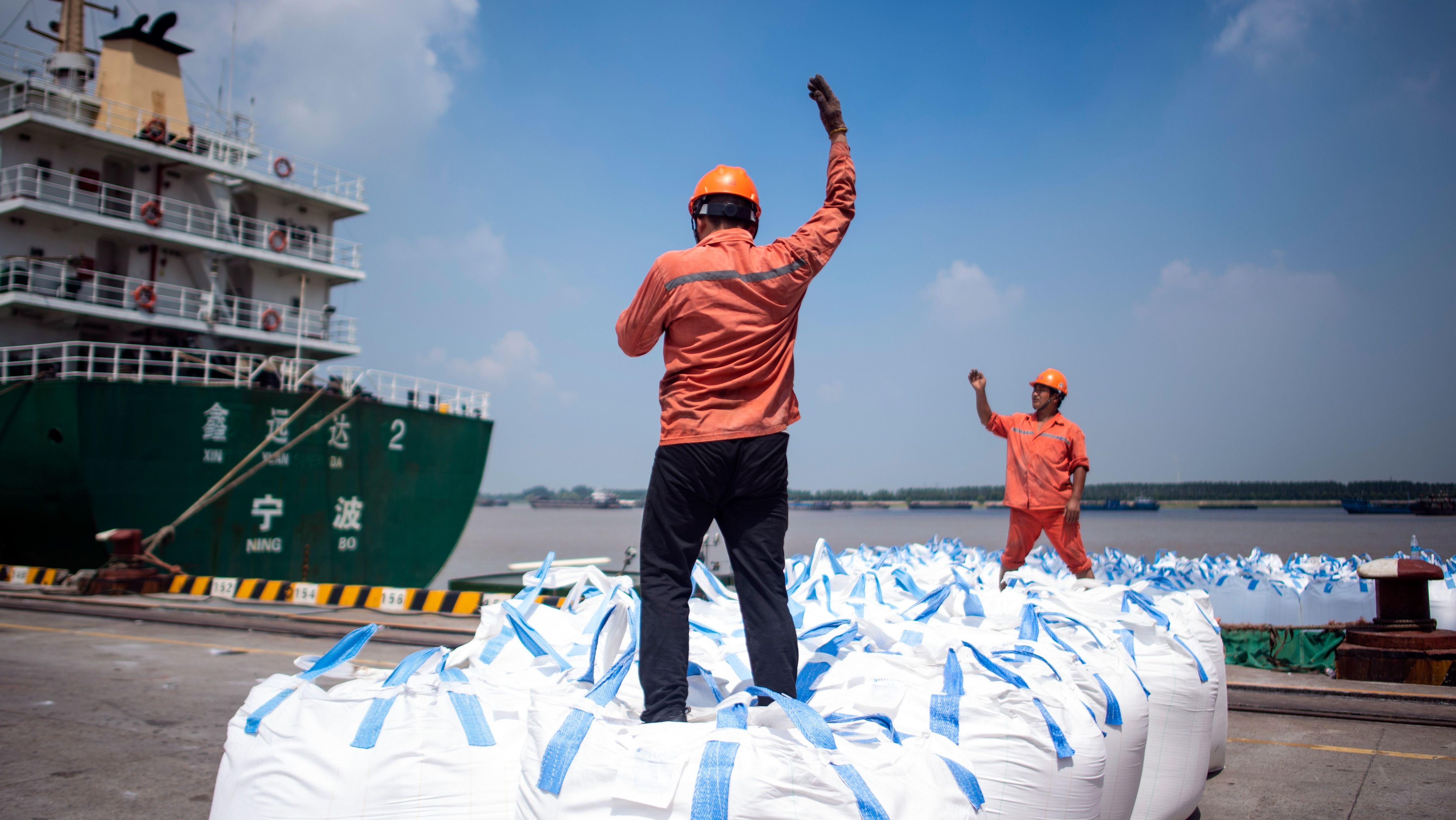 Dock workers unload bags of chemicals earlier this month at a port in Zhangjiagang, north of Shanghai. (AFP/Getty Images)