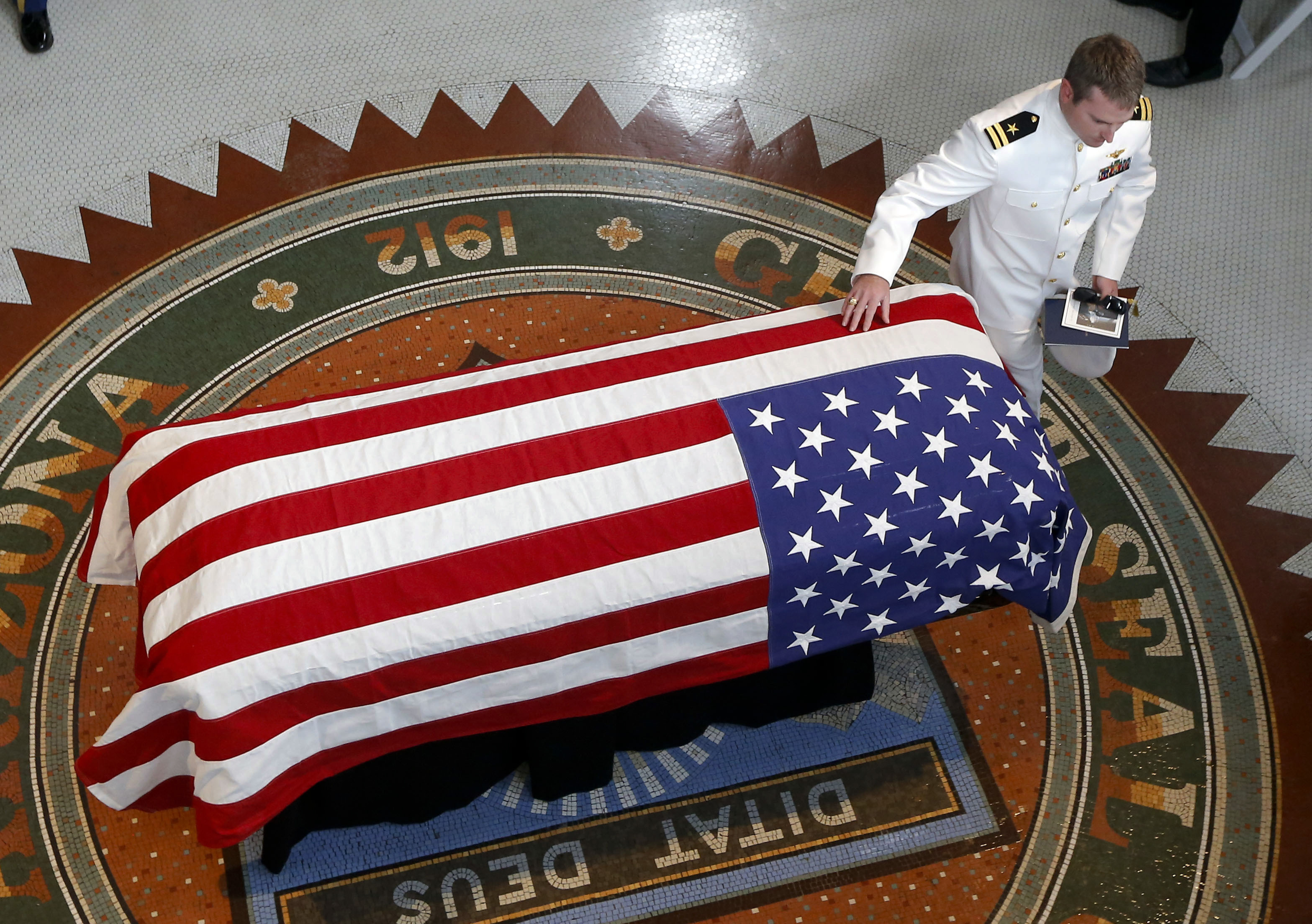 Jack McCain son of Sen. John McCain R-Ariz. touches his father's casket during a memorial service at the Arizona Capitol on Wednesday in Phoenix