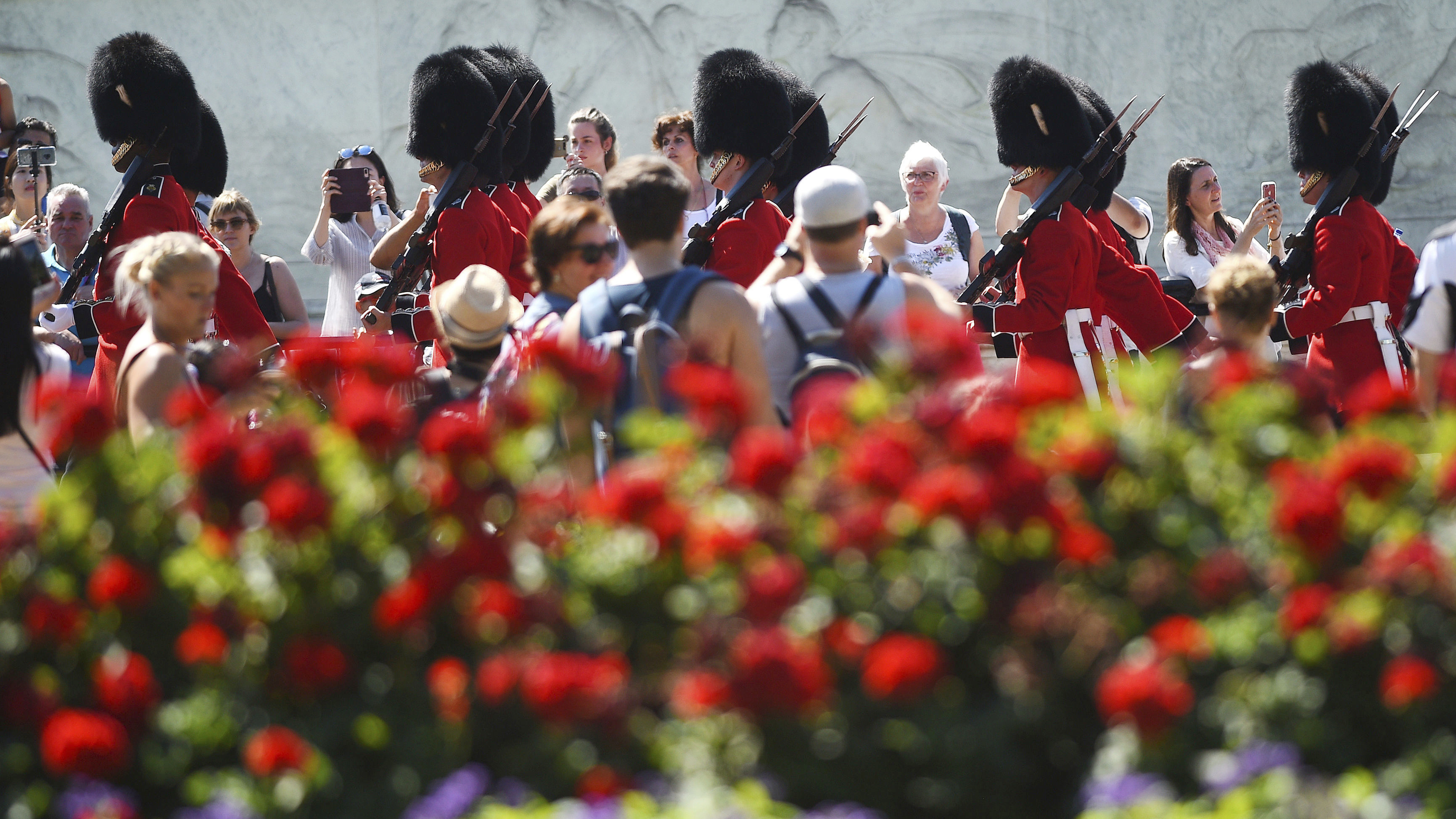 Spectators gather daily to watch the changing of the guard at Buckingham Palace in London. On Friday, a military band paid tribute to Aretha Franklin at the ceremony.