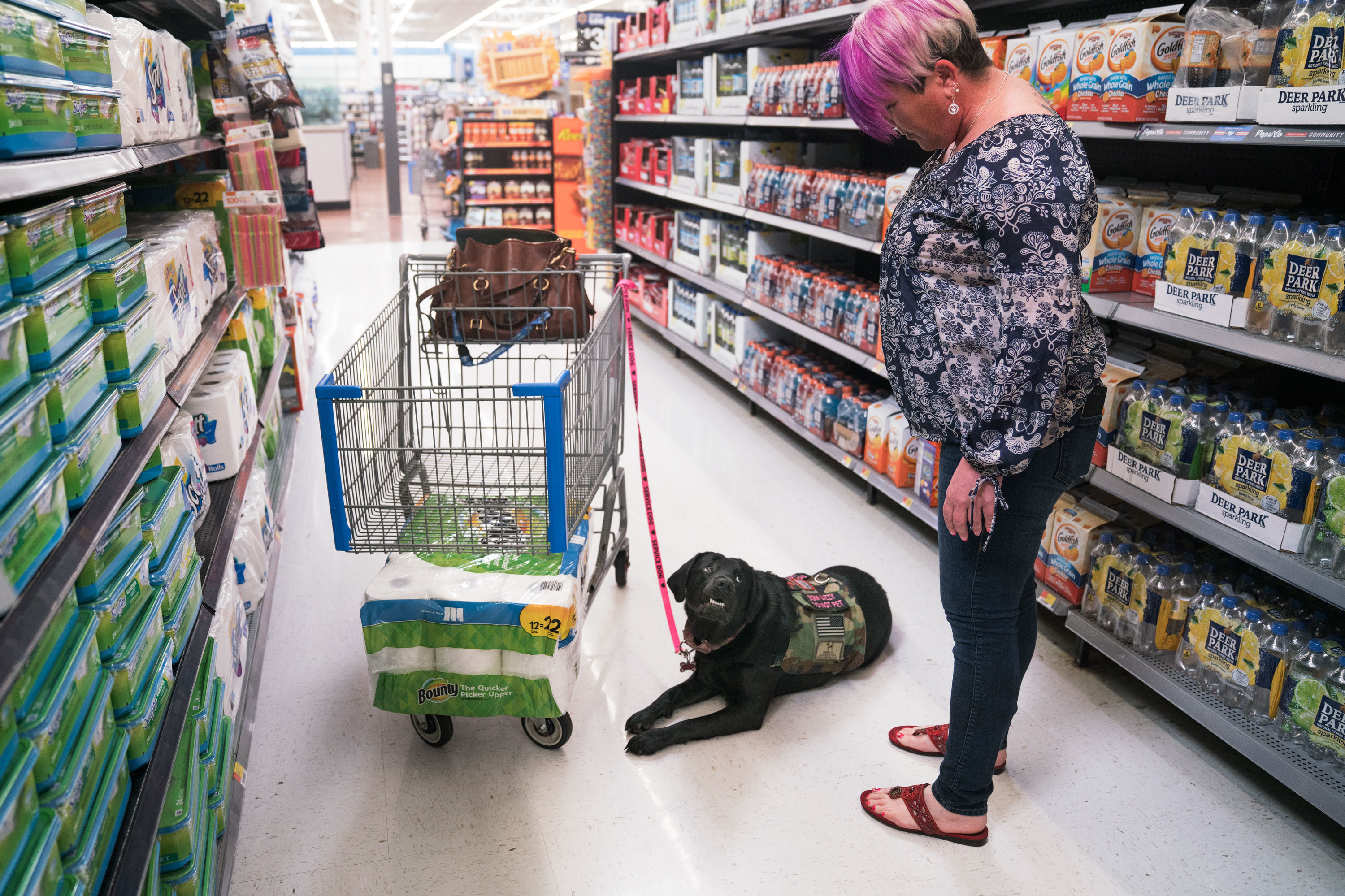 Leigh Michel with Lizzy, her service dog, attracts more attention than the average shopper at her grocery store. (NPR)