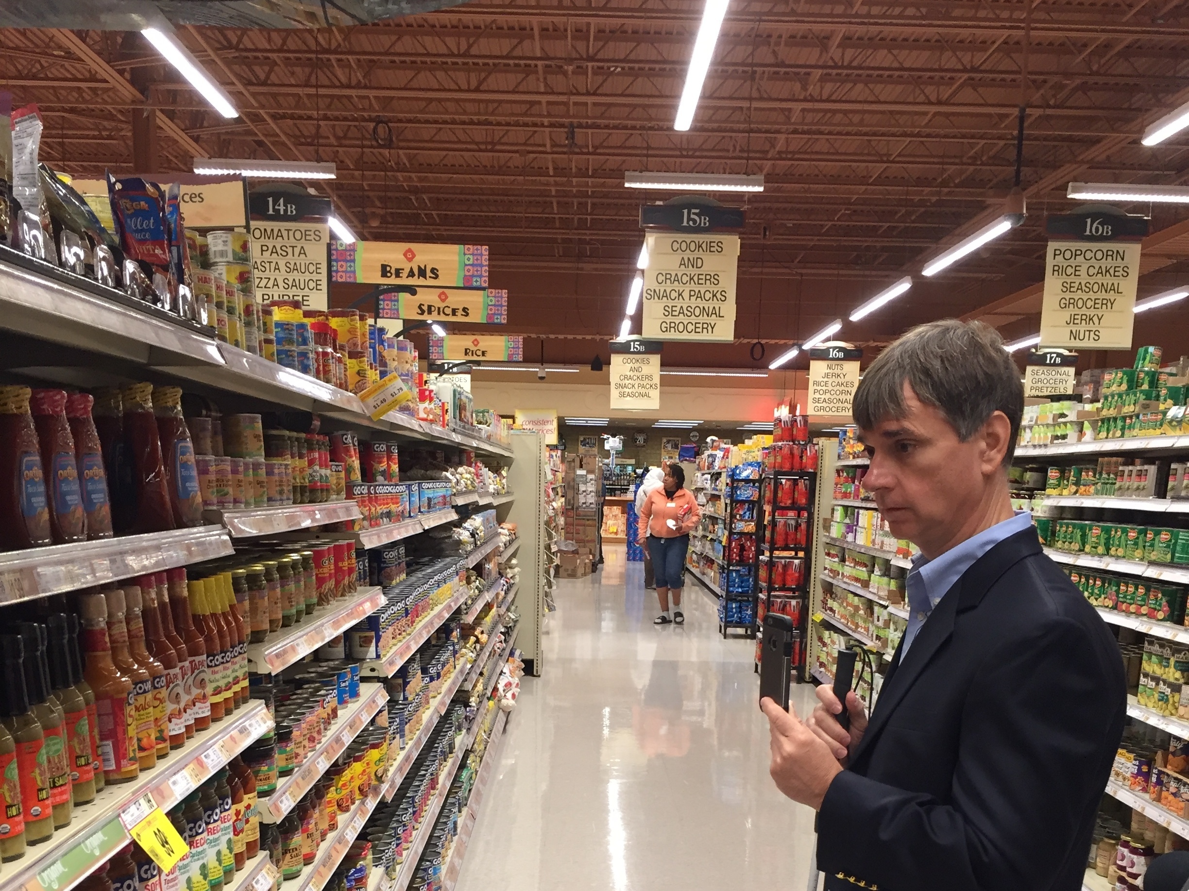 Gary Wagner, a blind Buffalo resident and subscriber to an app that connects him to a shopping assistant, looks for hot sauce at a Wegmans store in Amherst, New York. (WBFO)
