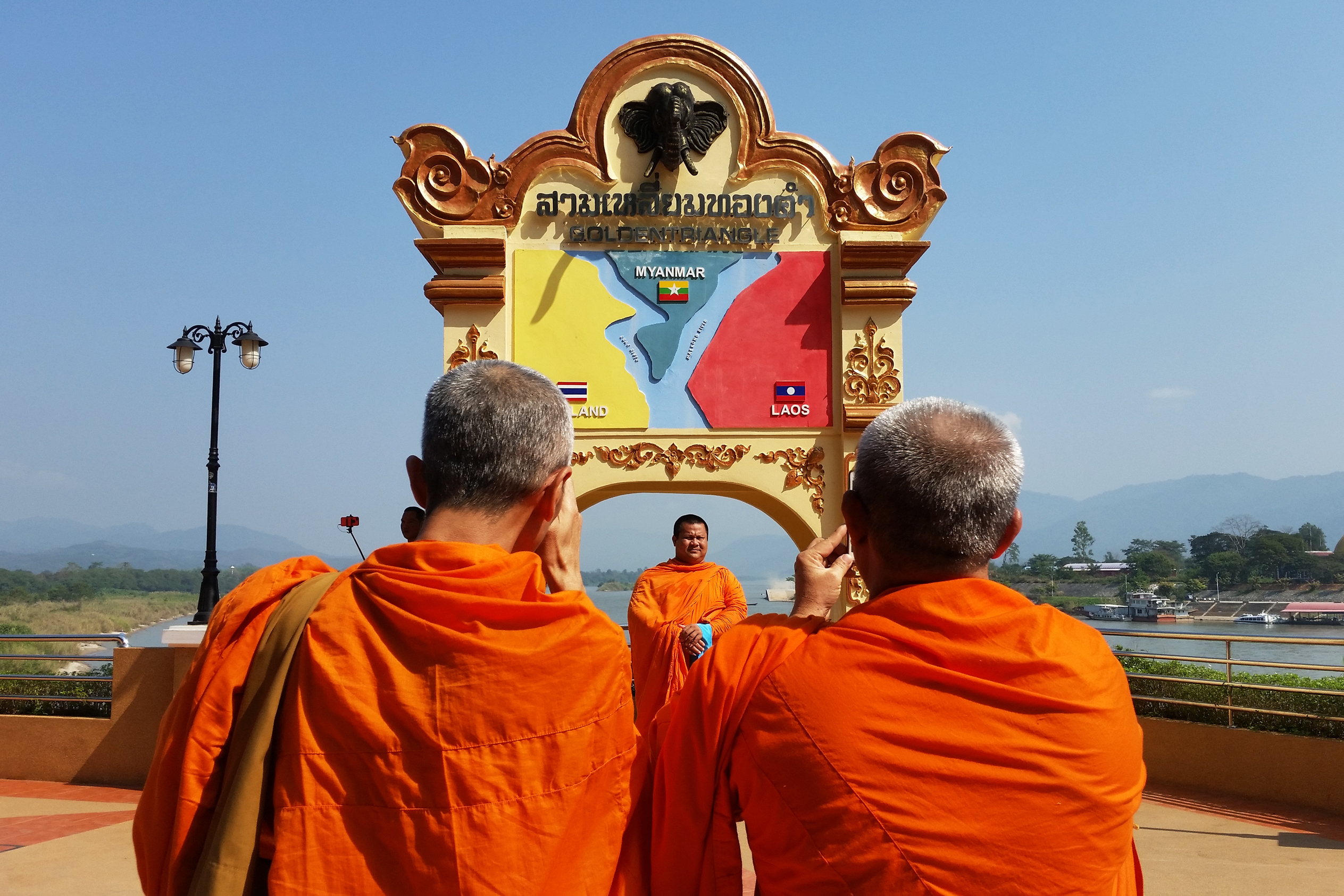 Buddhist monks snap photos on the Mekong in the town of Sob Ruak, northern Thailand, near the borders with Myanmar and Laos. (Michael Sullivan for NPR)