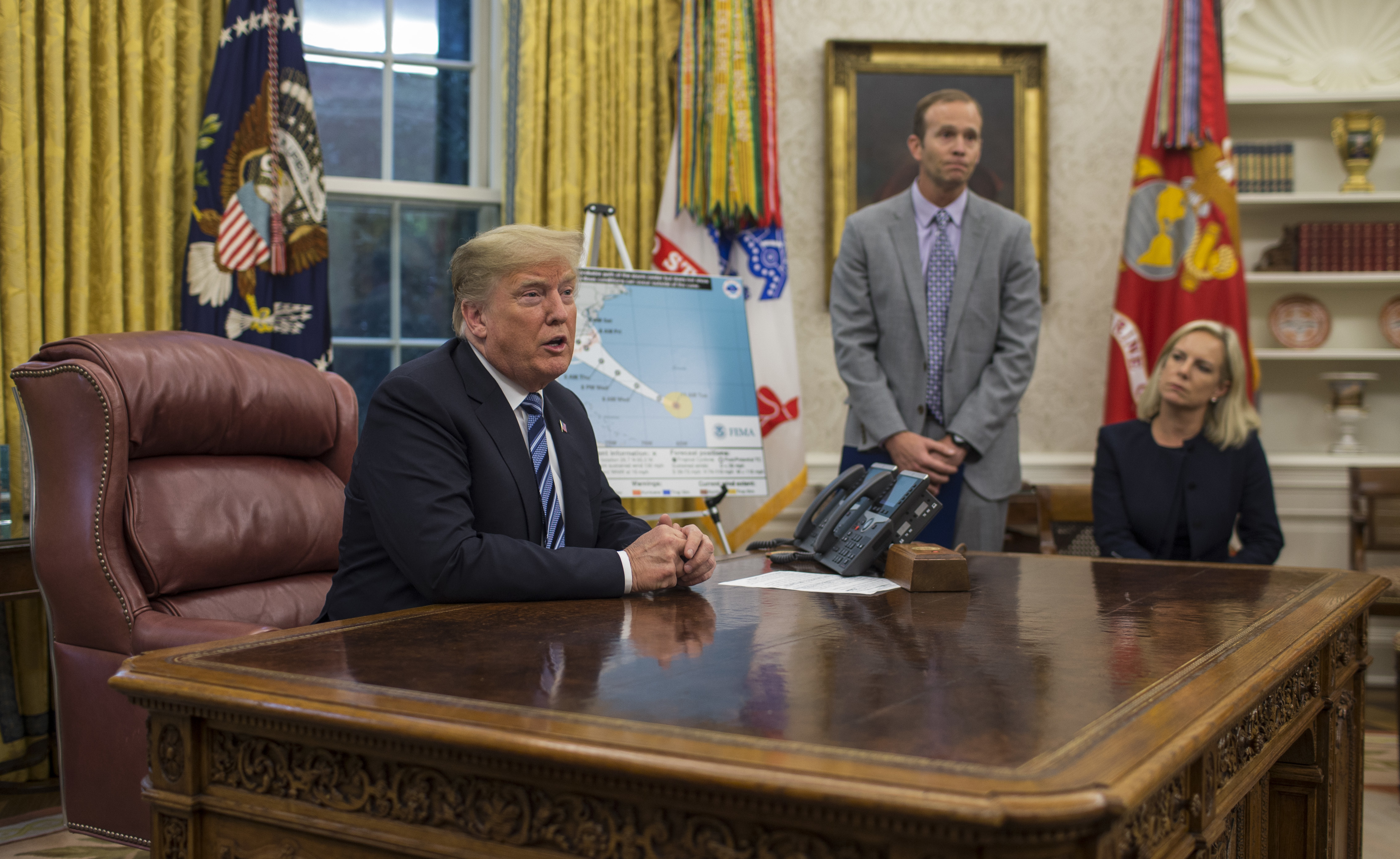 President Trump holds a briefing on Hurricane Florence in the Oval Office on Tuesday with FEMA Administrator Brock Long and Homeland Security Secretary Kirstjen Nielsen. (AFP/Getty Images)