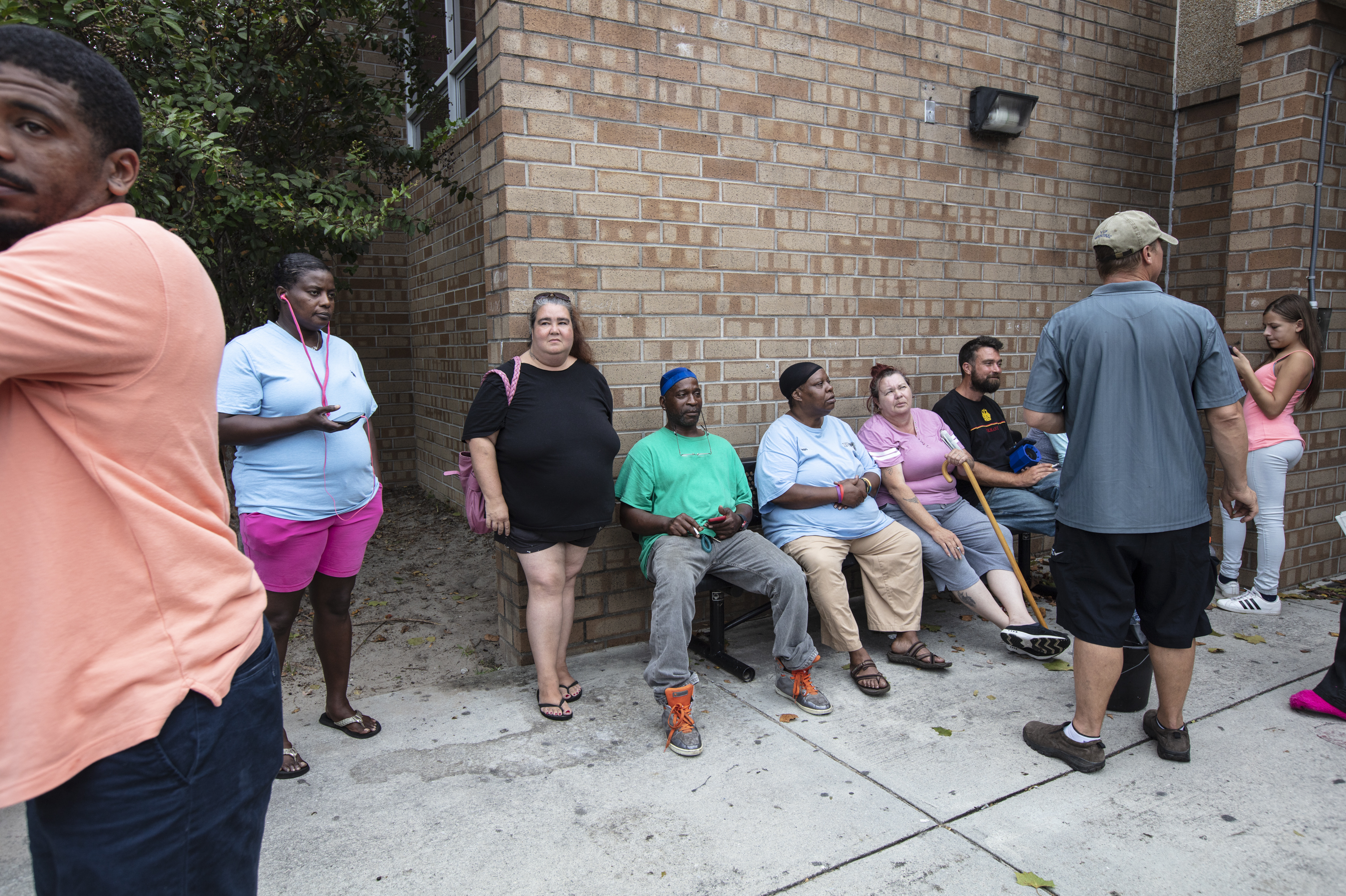 Evacuees sit outside the temporary shelter at Trask Middle School before Hurricane Florence arrives in Wilmington, N.C., on Thursday. (Phyllis B. Dooney for NPR)