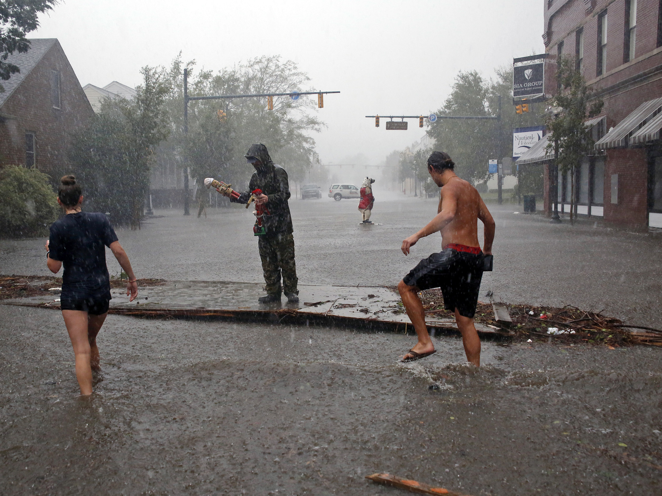 People survey damage and flooding brought by Hurricane Florence to Front Street in downtown New Bern N.C. Friday