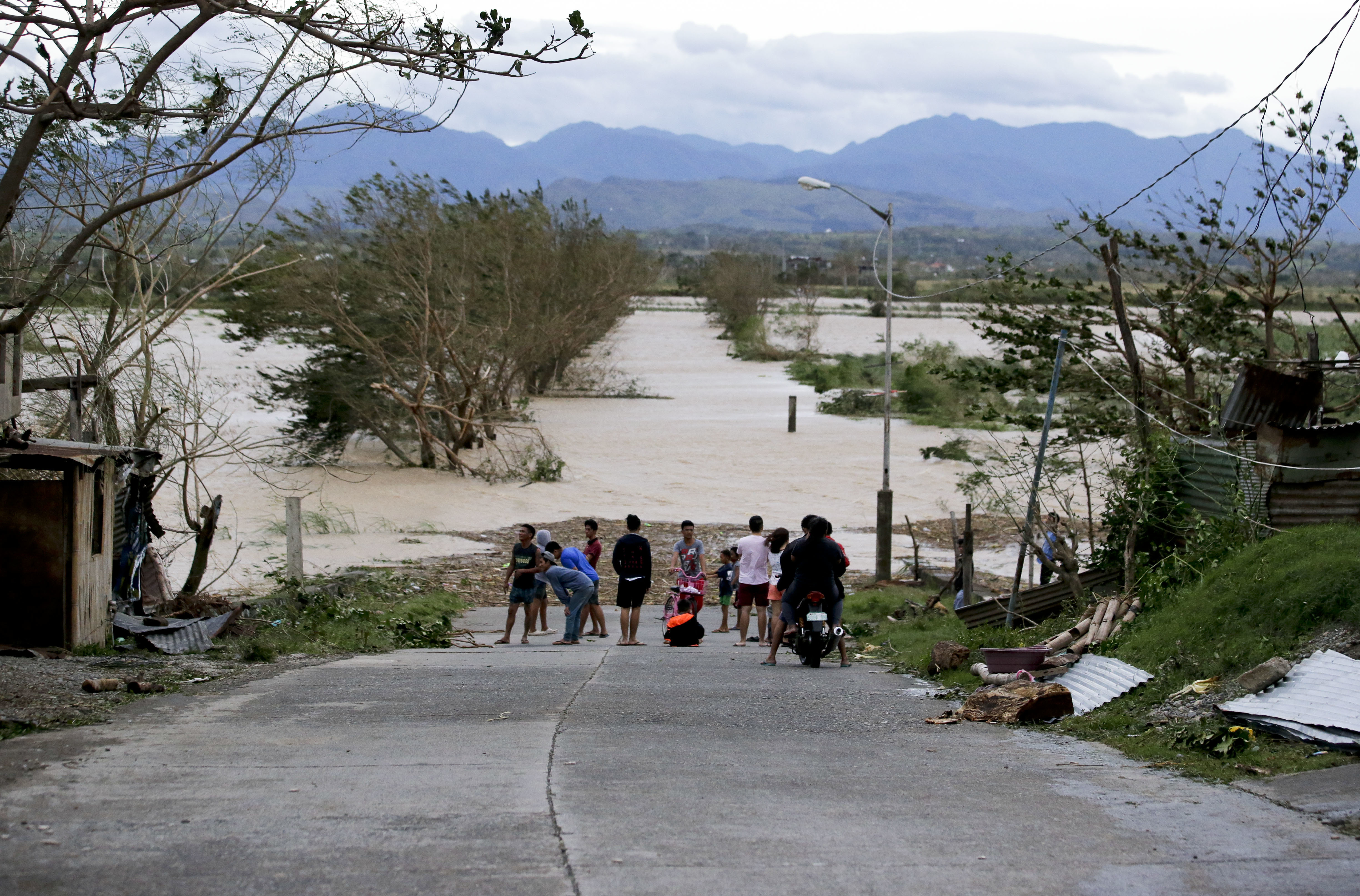 Residents stand by a flooded road following the onslaught of Typhoon Mangkhut in Tuguegarao city in Cagayan province, northeastern Philippines, on Sept. 15.