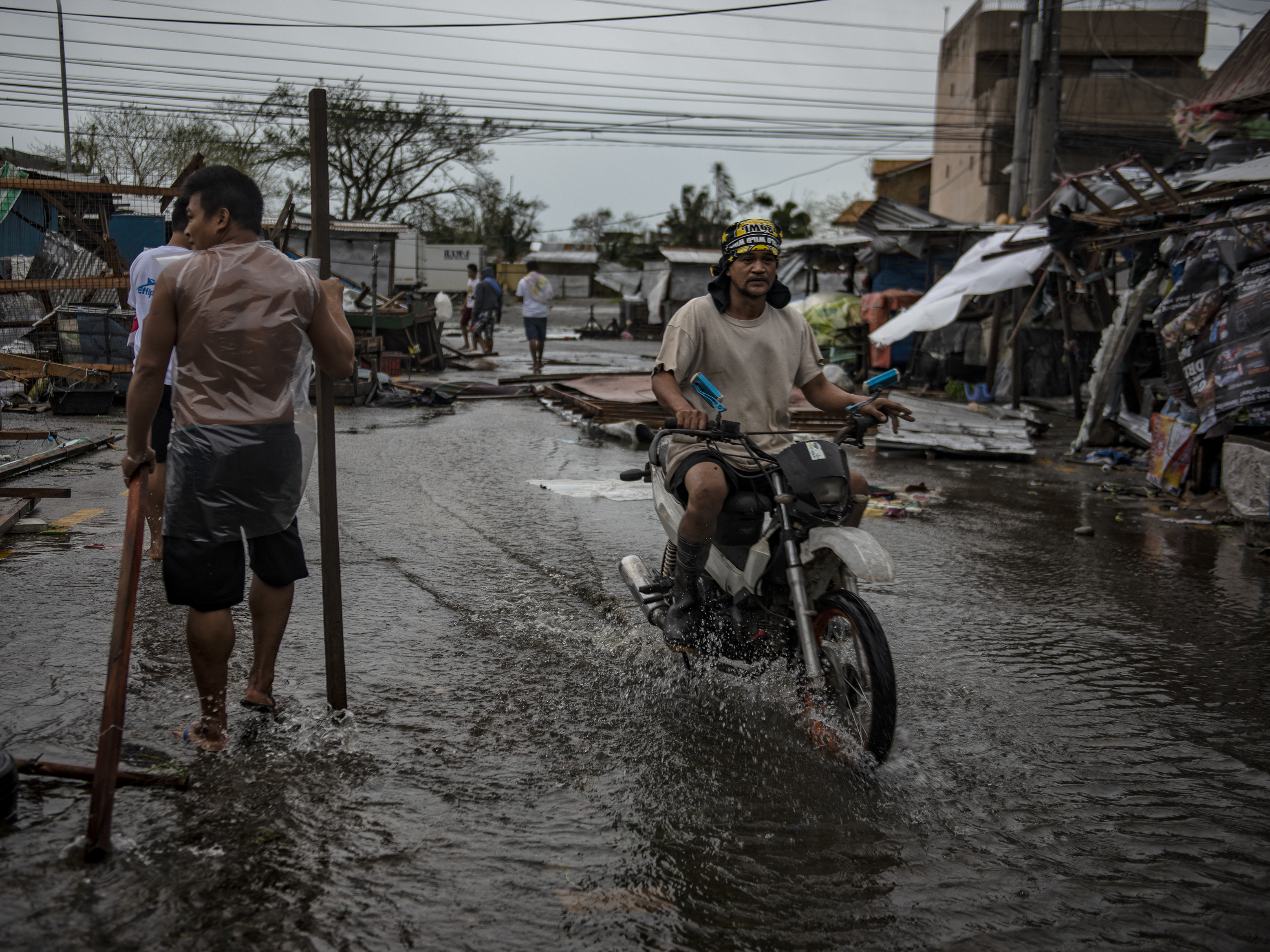 Residents walk on flooded streets as typhoon Mangkhut batters their city on Sept. 15 in Tuguegarao, Philippines. Typhoon Mangkhut hammered northern Philippines as it made landfall Saturday morning leaving at least 12 people dead.