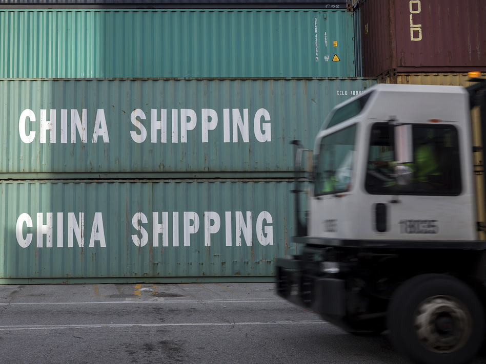 A truck passes a stack of Chinese shipping containers at the Port of Savannah in Georgia in July. (Stephen B. Morton/AP)