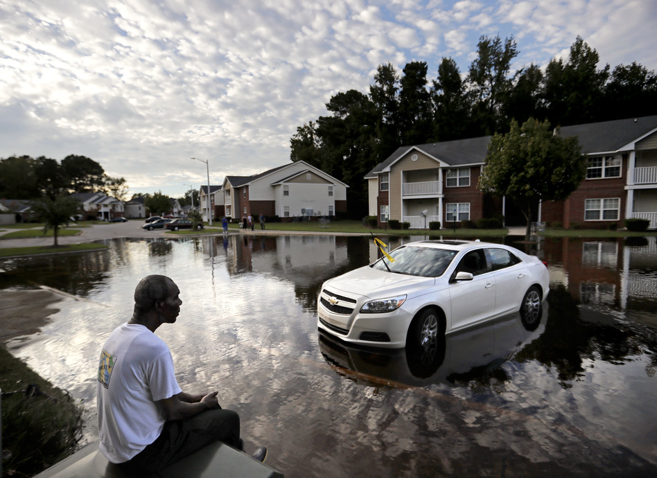 Augustin Dieudomme looks toward the flooded entrance of his apartment complex near the Cape Fear River in Fayetteville, N.C., on Tuesday, as the river continues to rise in the aftermath of Hurricane Florence. (David Goldman/AP)