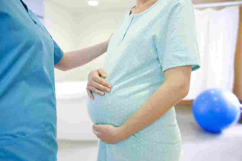 midwife or nurse talks to pregnant woman