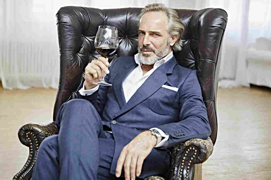 Portrait of a Man with Full Beard sitting in an Armchair holding a Glass of Wine