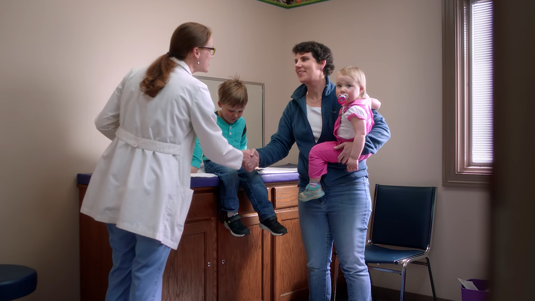 In one campaign ad about taking her kids to the doctor, Kentucky congressional candidate Amy McGrath nevertheless prominently features her military service. (Amy McGrath for Congress/Screenshot by NPR)