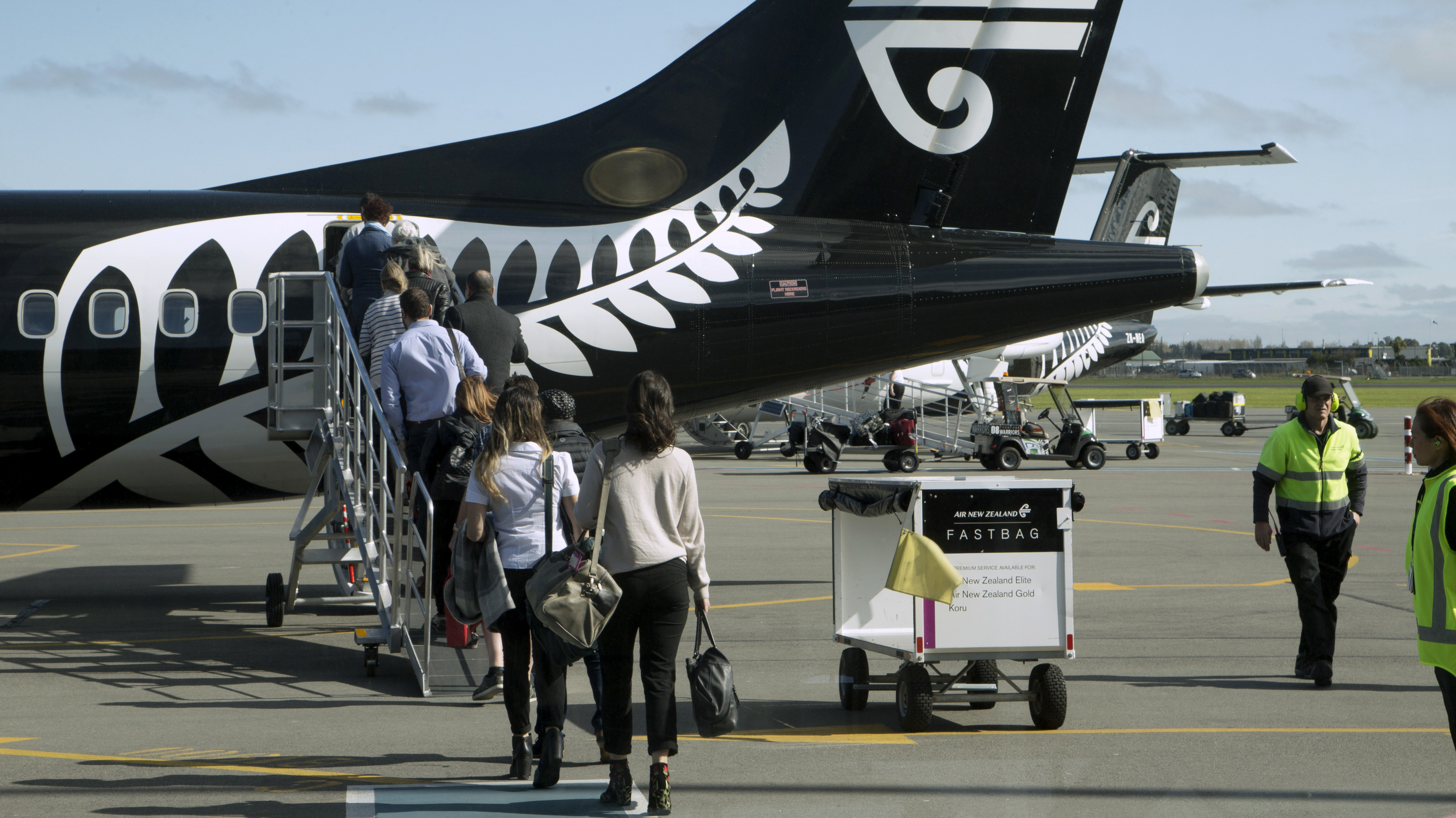 Passengers board an Air New Zealand flight at Christchurch Airport in New Zealand in 2017. A new law says arriving travelers may be fined for failing to provide a passcode or fingerprint to unlock electronic devices for customs agents.