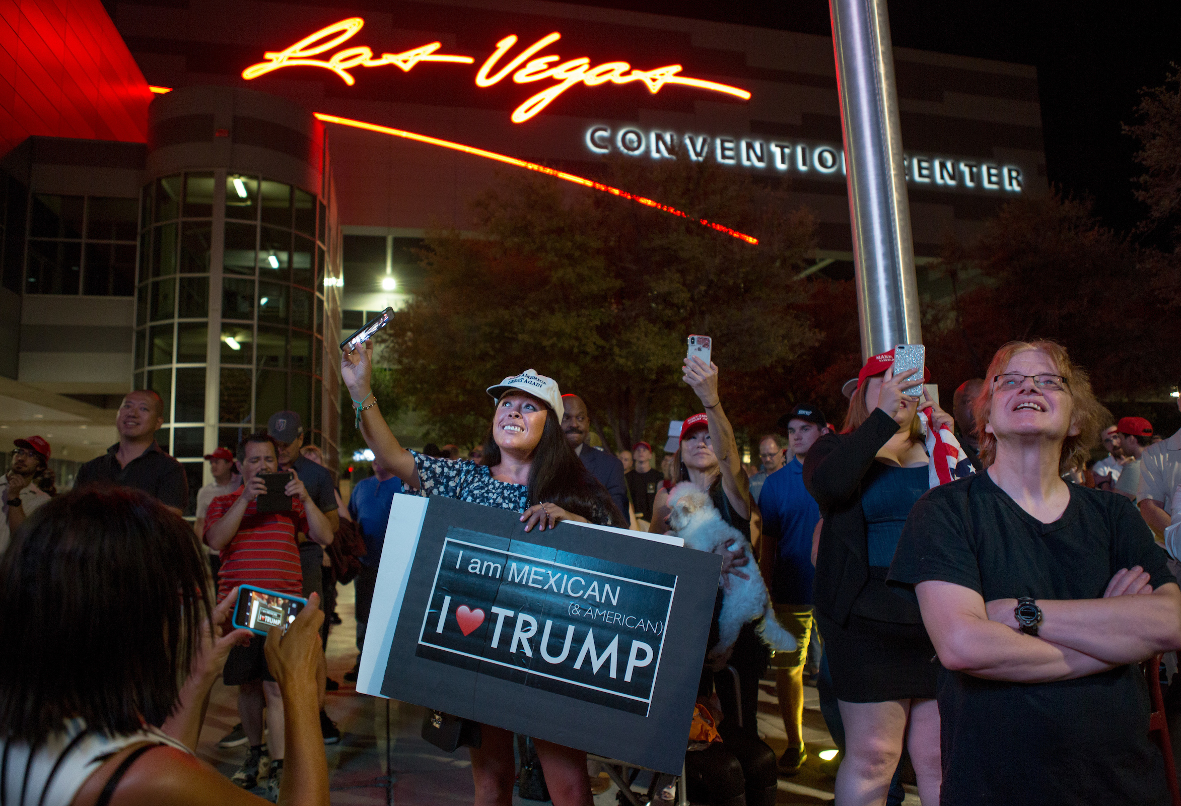 Supporters gather outside the Las Vegas Convention Center as they watch President Trump's rally on screens in the parking lot on Sept. 20. (Allison Shelley for NPR)