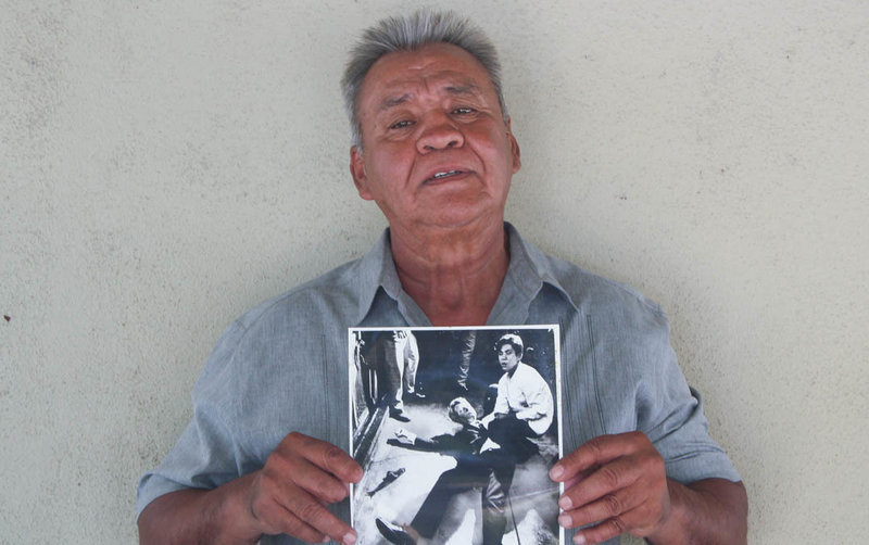 Juan Romero earlier this year at his home in Modesto, Calif., holding a photo of himself and Sen. Robert F. Kennedy, taken by <em>The Los Angeles Times' </em>Boris Yaro on June 5, 1968. Romero died this week at age 68. (StoryCorps)