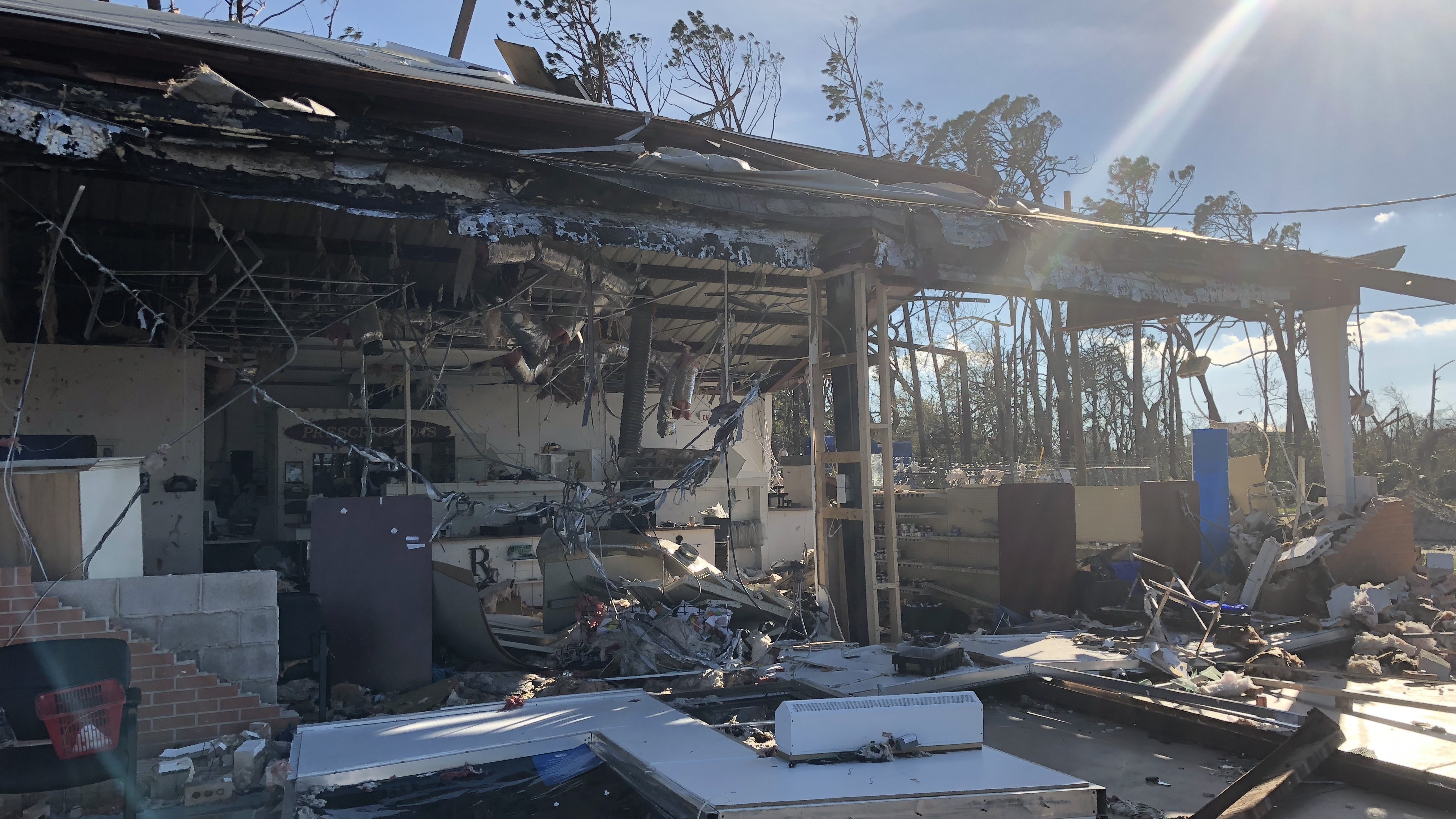 The walls and windows of this pharmacy in Lynn Haven, Fla., were blown out during Hurricane Michael, but pill bottles remained lined up on the shelves. The city saw widespread damage from Hurricane Michael, including roofs blown off and fallen trees. (NPR)