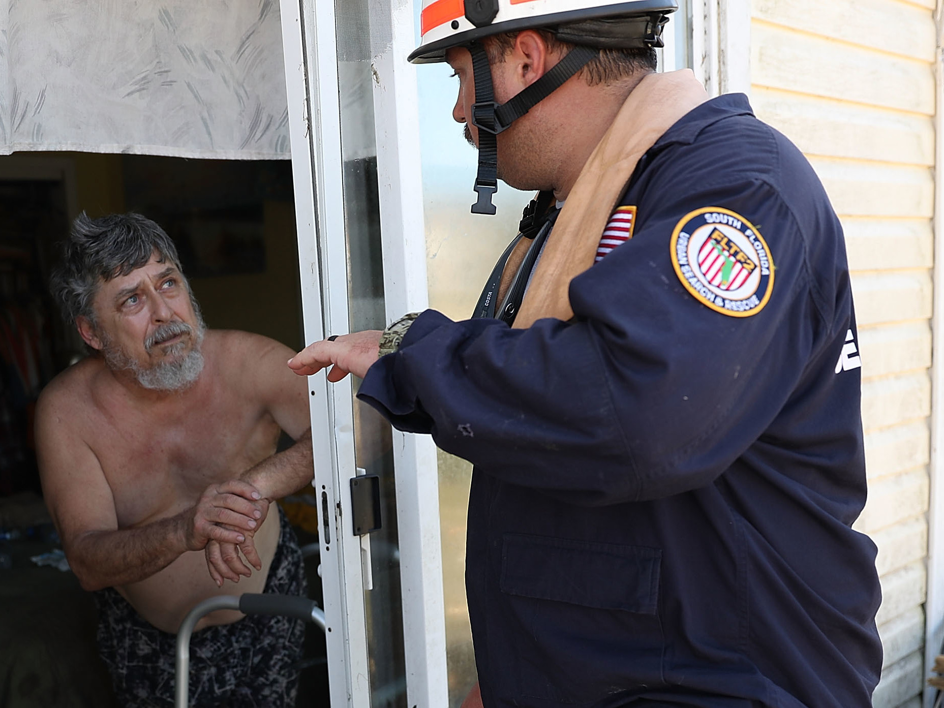 Brian Bartlett from the South Florida Search and Rescue team checks in on Tom Garcia, who stayed in his home through Hurricane Michael. Experts say people's decisions to stay are almost always carefully considered. (Getty Images)