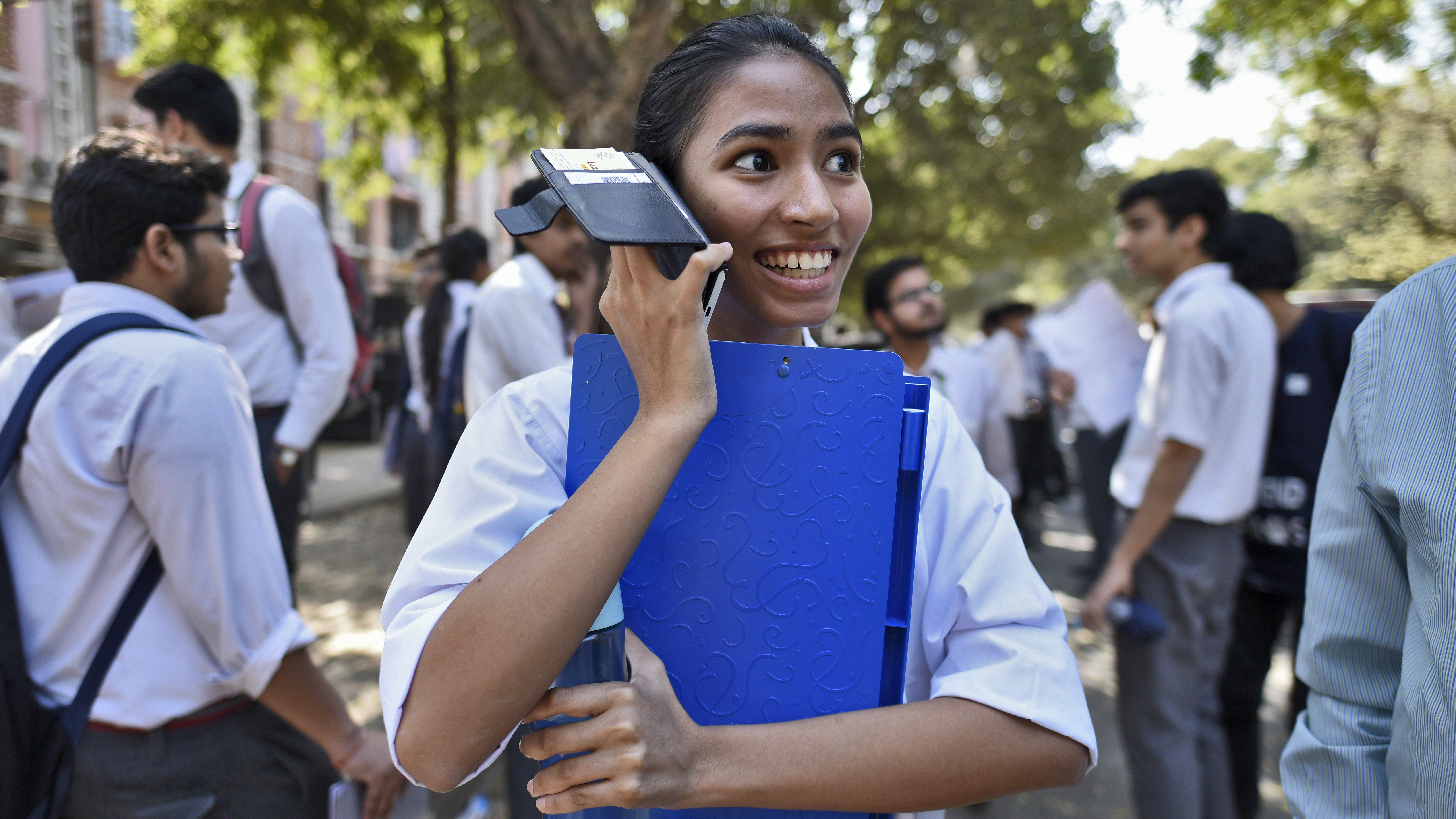 A girl talks on her mobile phone after coming out of class in New Delhi, India.