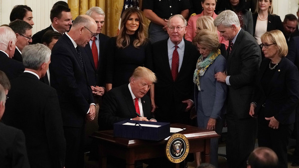 Flanked by lawmakers and first lady Melania Trump, President Trump participates in a bill signing to dedicate more resources to fight the opioid crisis during an East Room event at the White House Wednesday.