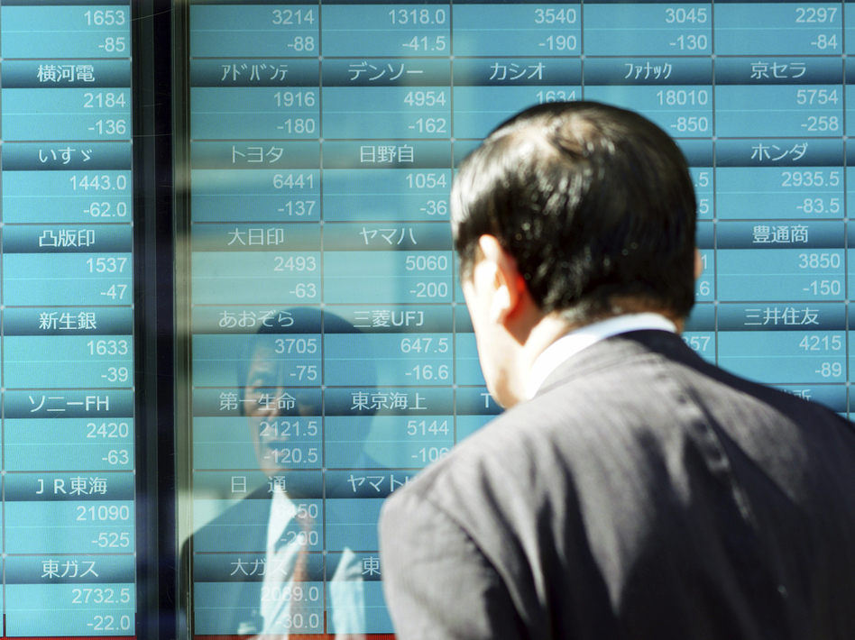 A man looks at an electronic stock board showing Japan's Nikkei 225 index on Thursday in Tokyo. (Eugene Hoshiko/AP)