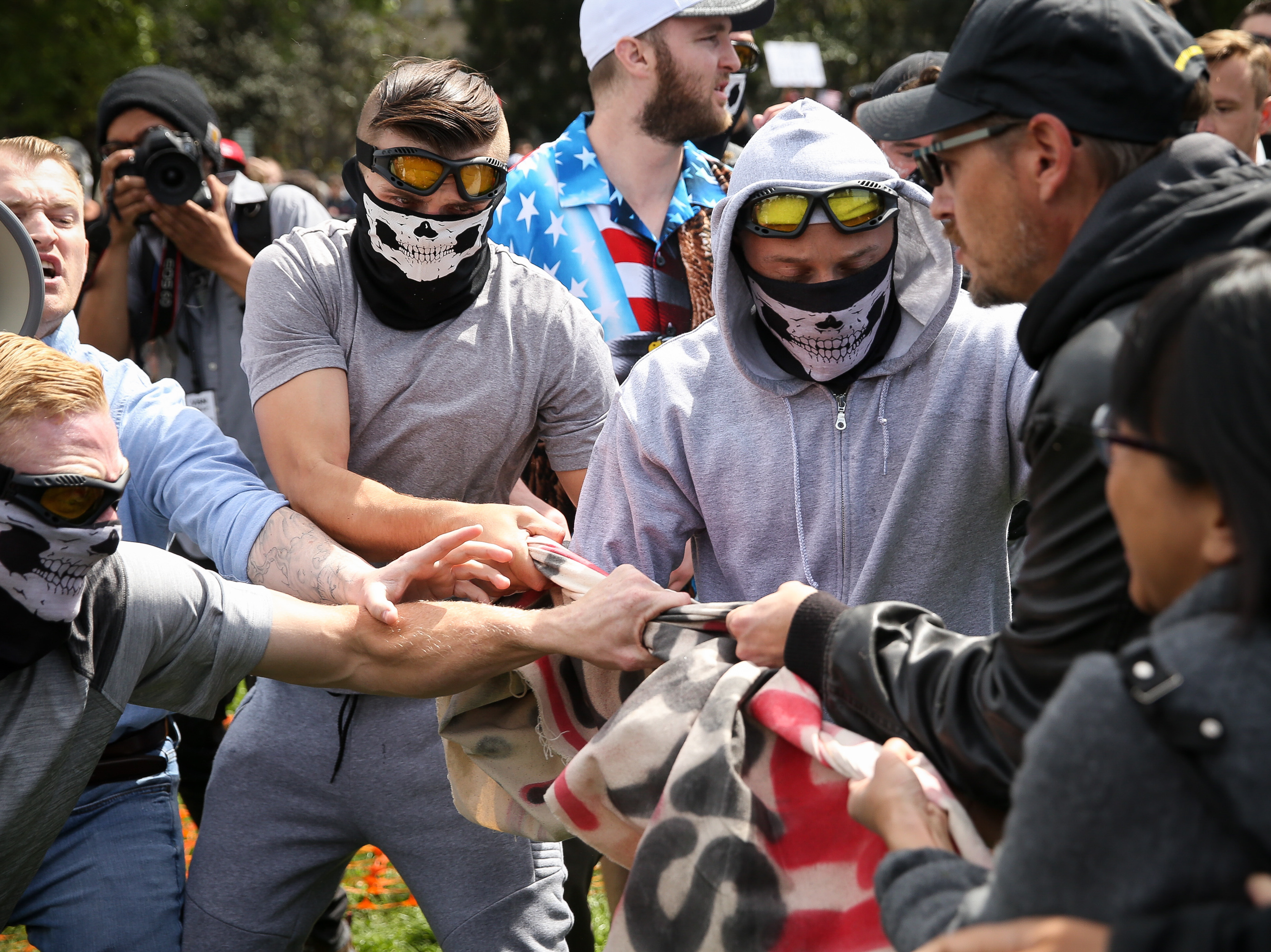 Rise Above Movement members wearing their skeleton masks pull away a counterprotester's flag at a Patriots Day rally last April in Berkeley, Calif. Four RAM members were arrested for violence at the rally and a string of others. (Getty Images)