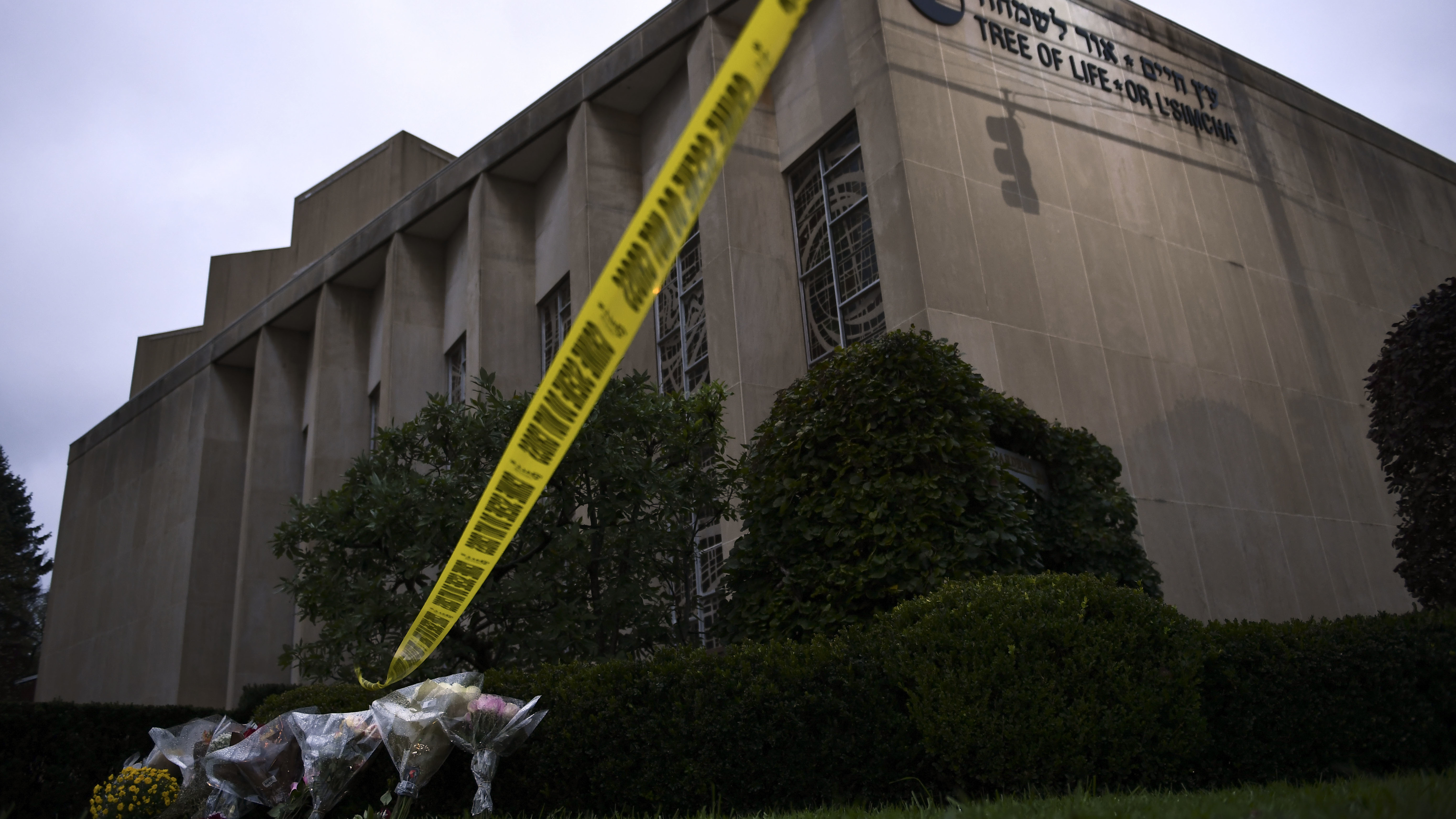 Police tape and memorial flowers are seen on Oct. 28, 2018, outside the Tree of Life Synagogue in Pittsburgh, Pa.