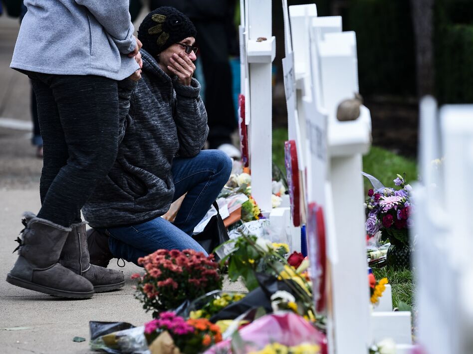 People pay their respects at a memorial outside the Tree of Life synagogue in Pittsburgh after a shooting there left 11 people dead. Many people see a connection between President Trump's anti-immigrant rhetoric and hate crimes. (Brendan Smialowski/AFP/Getty Images)
