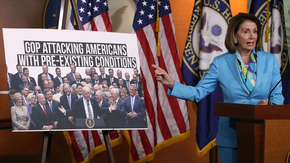 Democratic Minority Leader Nancy Pelosi, D-Calif., speaks about health care as she points to a picture of President Trump with House GOP members during her weekly news conference on Capitol Hill in June. (Mark Wilson/Getty Images)