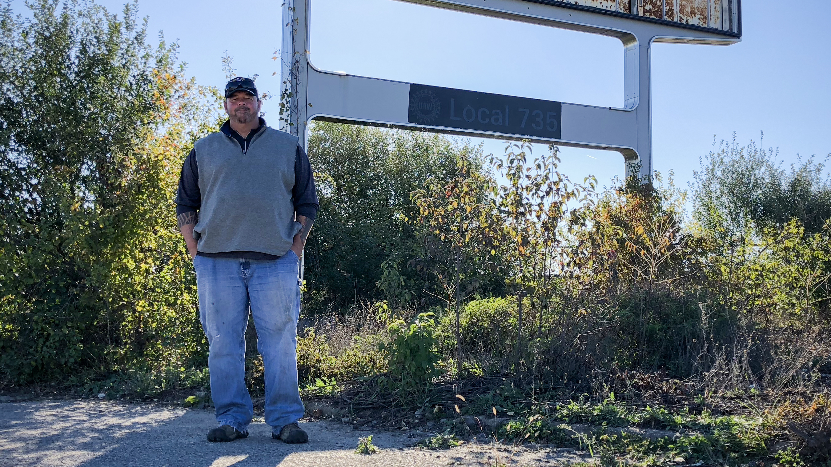 Don Skidmore stands in front of a sign for United Auto Workers Local 735, the union chapter he represented as president when he was a General Motors employee.