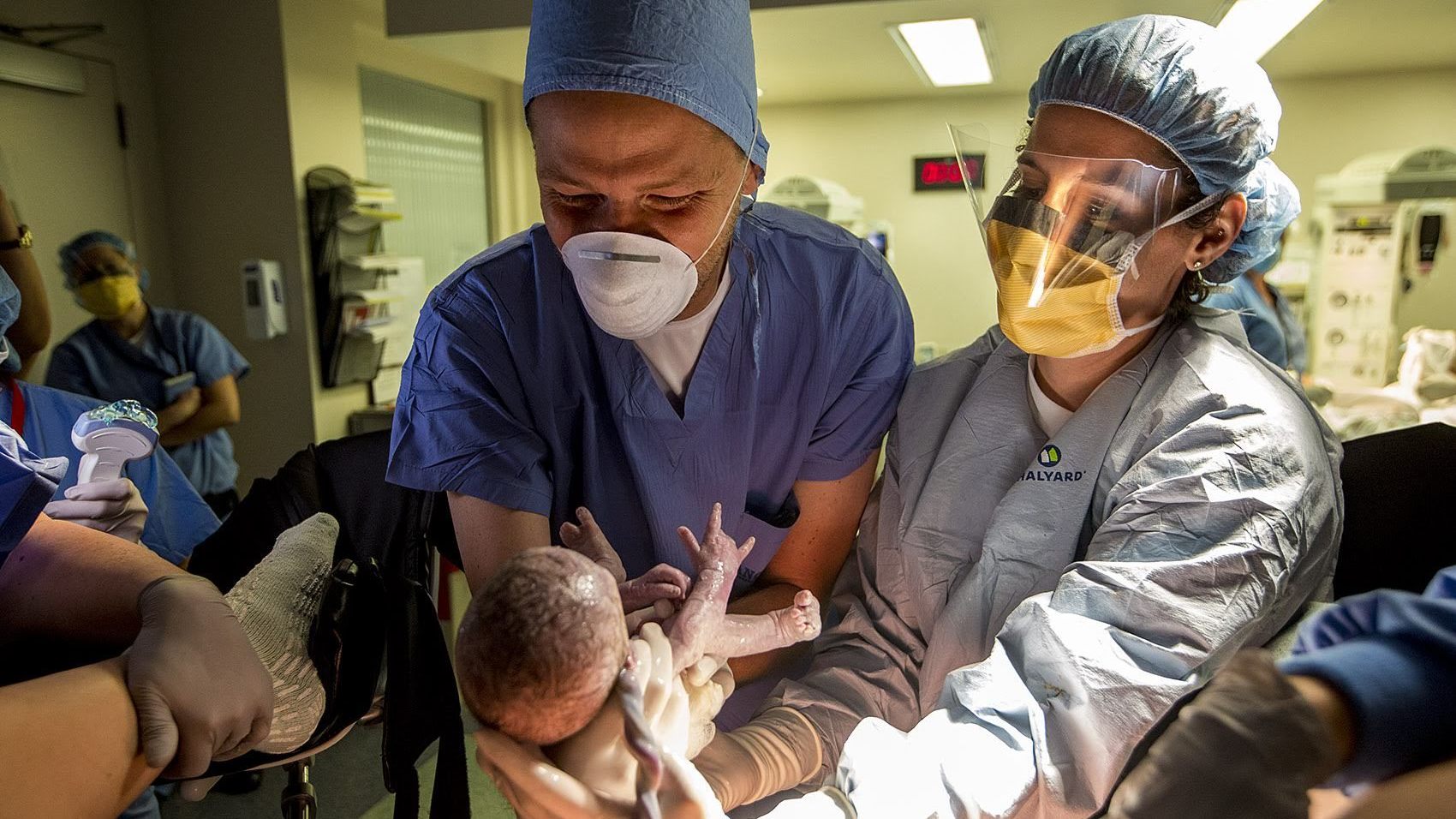 Dr. Ruth Levesque (right) hands Shaun McDougall his newborn son Brady at South Shore Hospital in Weymouth, Mass. The birth of the second twin, Bryce, was much trickier than Brady