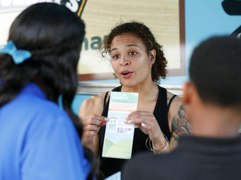 Jessica Jones (center) speaks to people gathered around the Ben & Jerry's "Yes on 4" Truck about Florida's Amendment 4 initiative at Charles Hadley Park in Miami, on Oct. 22. Amendment 4 asked voters to restore the voting rights of people with past felony convictions. (Wilfredo Lee/AP)
