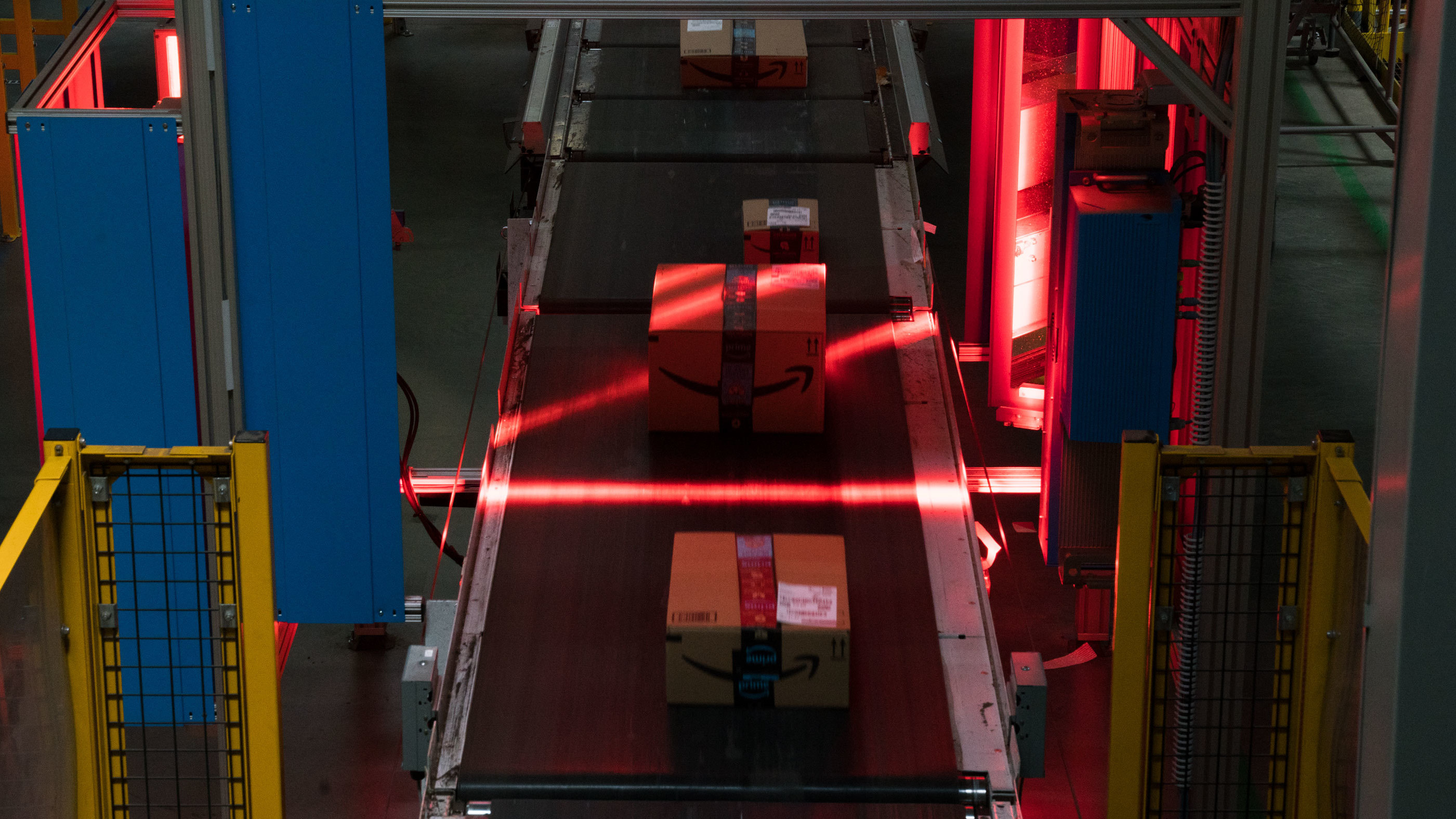 Amazon boxes are scanned on conveyor belts. AI systems keep track of all items in the warehouses, which can be as vast as 1 million square feet.