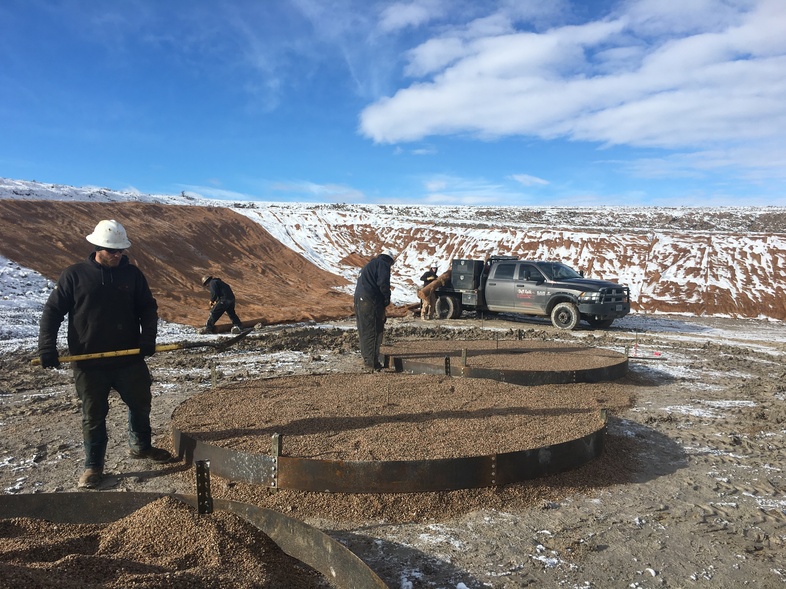 Workers at a Wold Energy Partners well pad in Wyoming place gravel where oil tanks will soon stand. A spike in drilling in the state is getting a boost from new lease sales on public land. (Cooper McKim/Wyoming Public Media)