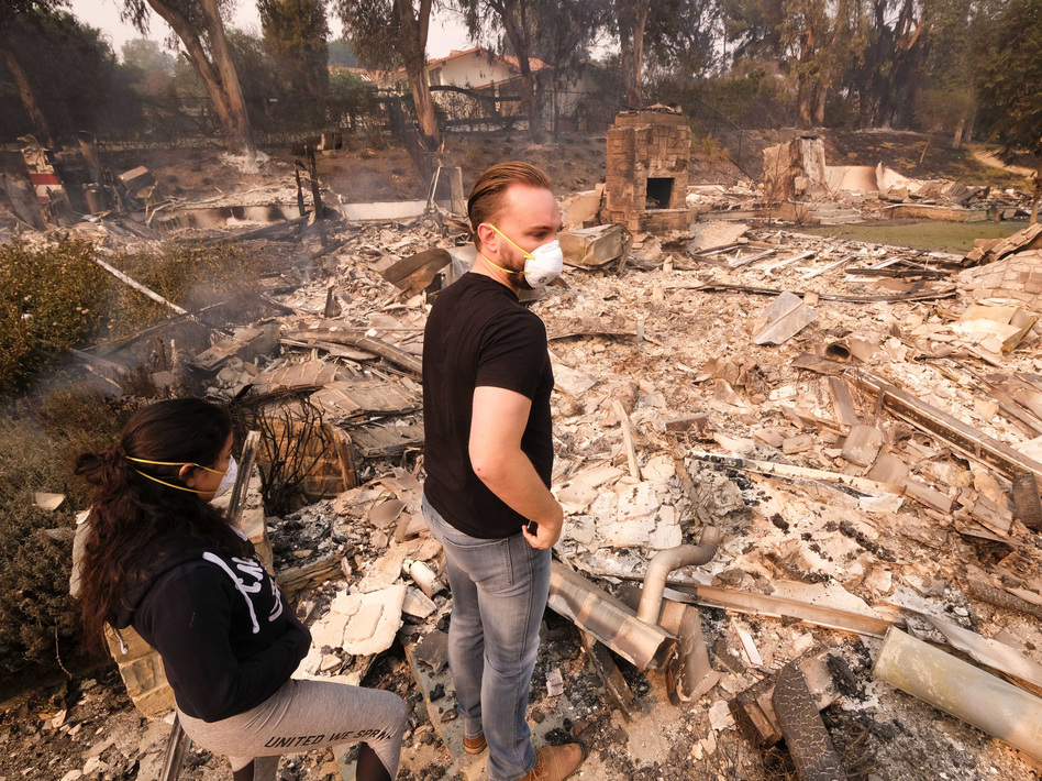 A California man and his girlfriend return to his burned-out home in Malibu on Saturday. (Ringo H.W. Chiu/AP)