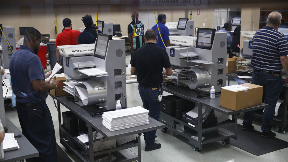 Workers load ballots into machines at the Broward County Supervisor of Elections office in Lauderhill, Fla. (Brynn Anderson/AP)