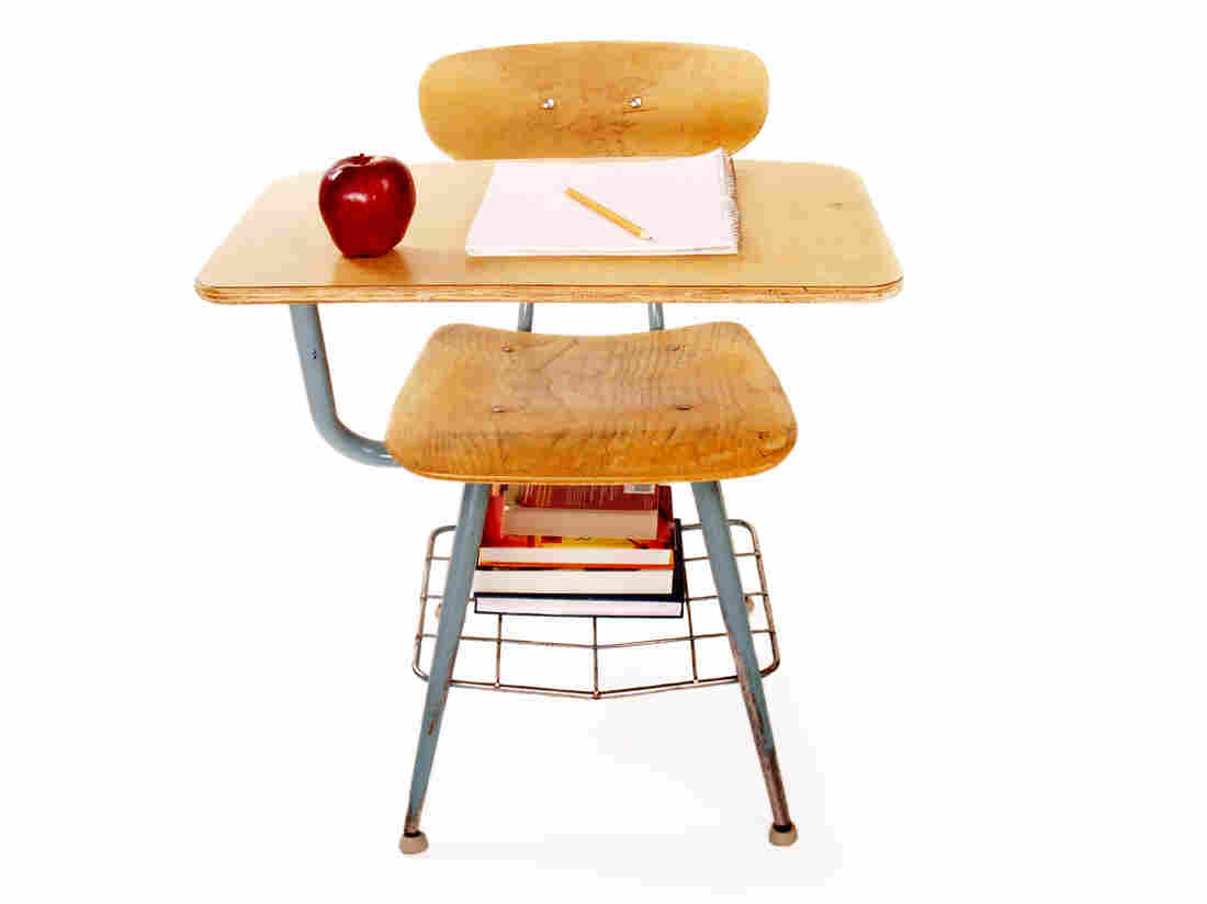 Full front view of an old student desk on white; copy space