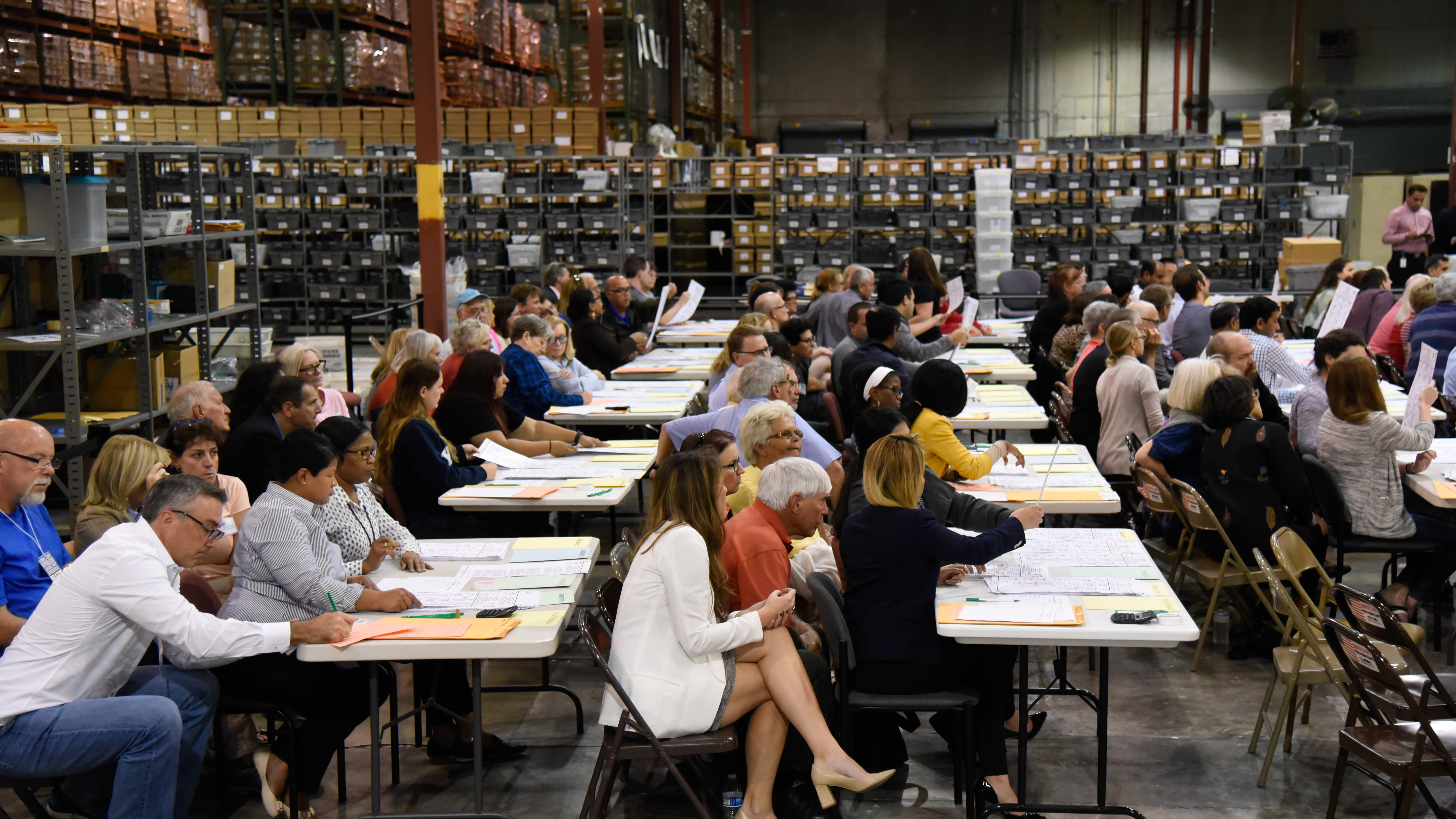 Volunteer observers keep watch Friday as election workers at tables examine ballots during a hand recount of votes cast in Palm Beach County for the U.S. Senate race. (AFP/Getty Images)