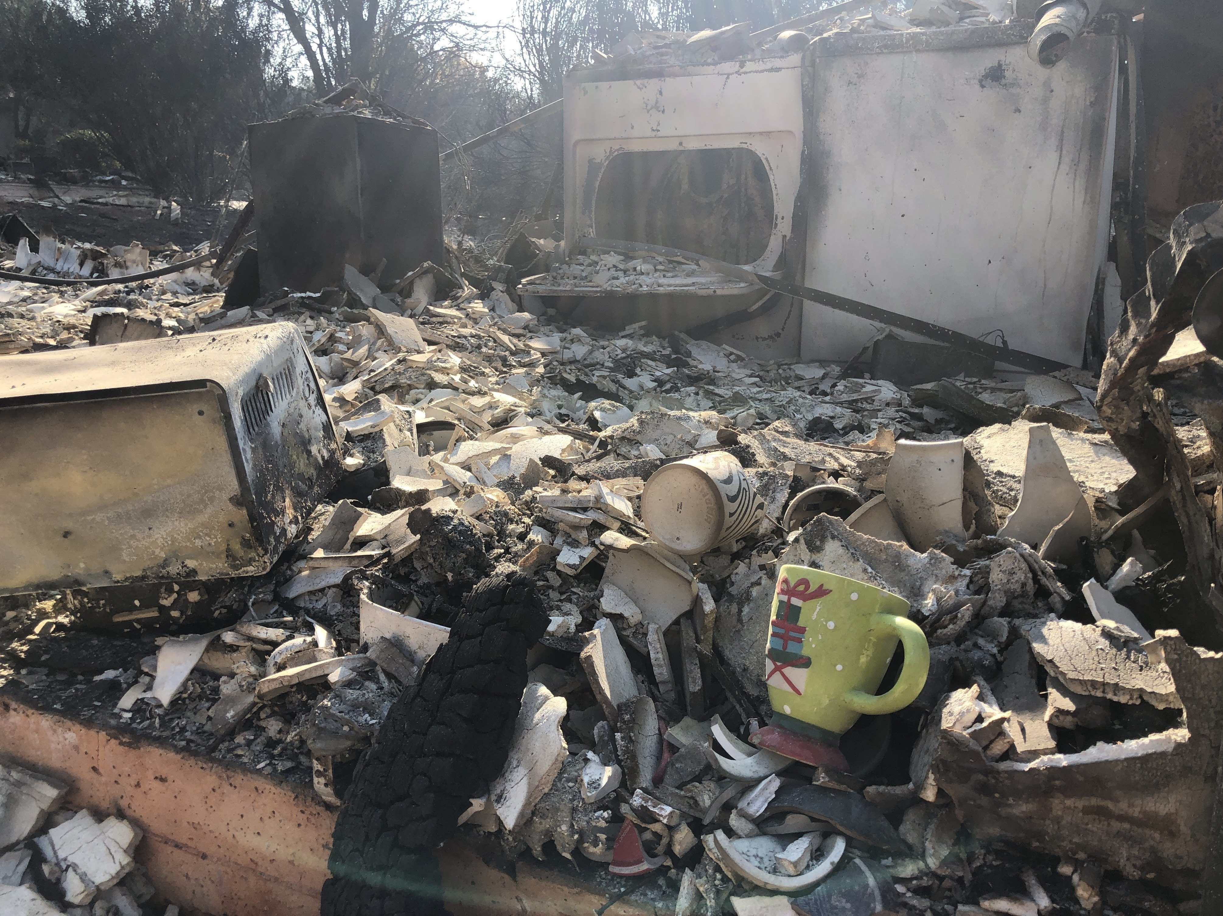 A holiday mug is seen among the wreckage of what was once someone's kitchen in Paradise, California. (NPR)